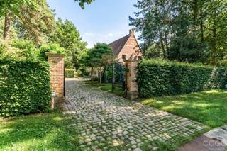 <p>Op het einde van een rustige, doodlopende straat bevindt zich deze karaktervolle kasteelvilla, bereikbaar via een stijlvolle inkompoort en een oprijlaan. De woning is gelegen op een prachtig perceel van 2.301 m² en geniet van maximale rust, privacy en een groene omgeving.</p>
<p>Via de royale inkomhal met statige trap betreedt u de woning. De sfeervolle leefruimte van ca. 66 m² straalt authenticiteit uit dankzij de Franse haard, natuurstenen kasteelvloeren en de open vide. De keuken (ca. 16 m²) biedt uitzicht op de veranda en het overdekte zwembad, waar zich tevens een douche en toilet bevinden. Verder beschikt het gelijkvloers over een gastentoilet en een inpandige dubbele garage.</p>
<p>De eerste verdieping omvat een ruime overloop en twee royale slaapkamers, elk met een eigen ensuite badkamer, en een aparte berging. Via een draaitrap bereikt u de zolderverdieping, waar zich nog twee ruime kamers en een bijkomende badkamer bevinden.</p>
<p>De prachtig aangelegde tuin vormt een oase van rust en biedt een uitzonderlijke combinatie van groen, privacy en ruimte.</p>
<p>Dit uniek eigendom dient gerenoveerd te worden, maar biedt een zeldzame kans om een karaktervolle villa met kasteelallure volledig naar eigen smaak en hedendaagse normen te renoveren. Een uitzonderlijk pand voor wie op zoek is naar charme, ruimte en een exclusieve ligging.</p>
