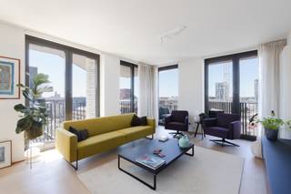 <p>Op de zevende verdieping van deze moderne residentie aan het Kattendijkdok ligt dit prachtig afgewerkt appartement met een uitzonderlijk panoramisch zicht over de stad Antwerpen, het MAS, het Havenhuis en het Kattendijkdok. Een absolute troef voor wie wil wonen in het hart van het bruisende Eilandje én op wandelafstand van de Schelde, de historische binnenstad en tal van gezellige horecazaken.</p>
<p>De open woonkamer, eetruimte en keuken vormen samen een aangename, lichtrijke ruimte die wordt omzoomd door imposante ramen van vloer tot plafond. Waar u ook zit, telkens opent zich een weids uitzicht. Voldoende plaats voor een comfortabele zithoek en een eettafel, met de open keuken als warm middelpunt van de woonst. De volledig geïnstalleerde keuken is stijlvol afgewerkt met marmeren werkbladen en een ruim kookeiland, aangevuld met kwalitatieve ingebouwde toestellen. <br />Het appartement telt twee slaapkamers. De hoofdslaapkamer beschikt over een praktische eigen dressing, terwijl de tweede slaapkamer voldoende flexibiliteit biedt voor kinderen, een thuiskantoor of een logeerkamer. De badkamer is tevens hoogwaardig afgewerkt met marmeren tegels, een ruime inloopdouche en dubbele wastafel — een verzorgd geheel met een luxueuze uitstraling.</p>
<p>Een echte meerwaarde van dit appartement zijn de twee terrassen, georiënteerd op het zuiden en het zuidwesten. Op de terrassen geniet u van een open zicht over de stad, het MAS, het Kattendijkdok en de skyline van de haven. Ideaal om buiten te ontbijten, te lunchen of ‘s avonds na te genieten van de laatste zonnestralen.</p>
<p><strong>Extra troeven</strong></p>
• Hoge berging naast de liften<br />• Dubbele ondergrondse staanplaats met laadpaal van 22 kW te koop aan €45.000<br />• Centrale ligging nabij winkels, horeca en openbaar vervoer<br />• Tijdloze afwerking met natuursteen doorheen het volledige appartement