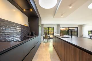 <p>Deze verzorgde woning met een breedte van 8 meter is gelegen in een aangename en kindvriendelijke omgeving met vlotte verbindingen naar winkels, scholen en invalswegen.</p>
<p>Inkomhal afgewerkt met travertin, die toegang biedt tot de garage (19m²) met manuele poort en een lavabo in meubel. <br />Wasplaats op tegelvloer, eveneens voorzien van een lavabo. Vanuit de inkomhal is er tevens toegang tot het gastentoilet.</p>
<p>Via een glazen deur bereikt u de lichtrijke leefruimte (68m²) met open keuken. De ruime woonkamer op travertin is uitgerust met meerdere lichtkoepels, een gashaard (2023) geïntegreerd in een maatmeubel. De volledig uitgeruste MIELE-keuken (2023) beschikt over alle hedendaagse comfort zoals een dubbele spoelbak, <span><span>Quooker</span></span> kraan, vaatwasser, koelkast, diepvries, inductiekookplaat, dampkap, combi-oven, warmhoud-lade en een heteluchtoven. Het centrale werkeiland met werkblad in dekton vormt het hart van de keuken en wordt aangevuld met een gezellige ontbijthoek en een vaste zitbank in de eethoek.</p>
<p>Verdieping: <br />Nachthal met toegang tot drie volwaardige slaapkamers (22m²/11m²/11m²) afgewerkt met laminaatvloer, een badkamer uitgerust met ligbad, douche, lavabo in meubel en handdoekdroger, een apart toilet en een praktische berging.<br /><br />Dakverdieping:<br />Zolder (78m²) bereikbaar via een vaste trap, waar de mogelijkheid bestaat om nog twee of drie extra slaapkamers te creëren.</p>
<p>De woning beschikt over een gezellige tuin met een ruim terras van 32 m² en sfeervolle tuinverlichting. <br />Achteraan bevindt zich een overdekt terras van 24 m², ideaal om het hele jaar door te genieten van het buitenleven. (momenteel gebruikt als bergruimte)<br /><br /><span>Extra:<br /></span>* EPC B<br />* CV op gas incl. radiatoren 2023<br />* 16cm isolatie in plat dak<br />* 8cm isolatie in zadeldak<br />* Kruipkelder<br />* Vloerisolatie<br /><br />Rustig gelegen op wandelafstand van de vaart en het centrum.</p>