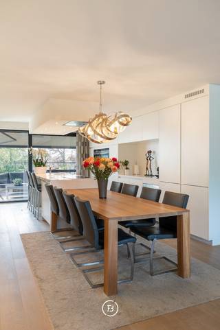 Dit ruim en lichtrijk penthouse van 147 m² (bruto) biedt uitzonderlijk veel wooncomfort in het centrum van Schulen. Met een prachtig groen uitzicht en twee grote terrassen van elk ruim 33,5 m² geniet u hier op elk moment van de dag van de zon en de rust. Het appartement beschikt over een royale leefruimte met een mooie open keuken en kookeiland, twee volwaardige slaapkamers, maatwerk, dressing en twee ruime badkamers. In de verkoop is bovendien een garagebox, een extra private autostaanplaats én een kelderberging inbegrepen. Op vlak van energie en techniek scoort de woning uitstekend met EPC label A (E-peil E47), vloerverwarming, zonnepanelen, domotica, verhoogde akoestische isolatie en een waterontharder. Het pand bevindt zich in een kleinschalige en uitstekend onderhouden residentie met een mooie tuin en bezoekersparking, rustig gelegen nabij de dorpskern, winkels en met een vlotte verbinding naar de snelwegen.