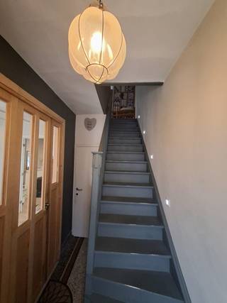 In het landelijke Wichelen vindt u deze charmante rijwoning met een prachtige, goed onderhouden tuin. De woning weet meteen te bekoren dankzij haar authentieke stijl en warme, gezellige uitstraling. Met maar liefst vier slaapkamers is dit de ideale gezinswoning.<br />Via de inkomhal, voorzien van een gastentoilet, betreedt u door de stijlvolle dubbele houten deur de woonkamer, die is opgedeeld in twee delen. Uw blik zal ongetwijfeld vallen op de ingebouwde boekenkast die voor karakter zorgt. Achter de dubbel houten vouwdeur bevindt zich het tweede gedeelte van de woonkamer, waar een allesbrander voor extra gezelligheid zorgt. De woning wordt zowel op het gelijkvloers als op de verdieping verwarmd op aardgas. Op het gelijkvloers is de oude Italiaanse gietvloer bedekt met laminaat dewelke wel aan vervanging toe is.<br />De landelijke keuken, afgesloten van de woonkamer met een glazen deur, is uitgerust met de nodige toestellen. Aansluitend vindt u een praktische bijkeuken met extra opbergruimte en plaats voor was en droogmachine.<br />Op de eerste verdieping bevinden zich drie slaapkamers en een badkamer met ruime inloopdouche en tweede toilet. De vierde slaapkamer ligt op de zolderverdieping, bereikbaar via een vaste trap. Dankzij de 4 maxi veluxramen komt heel wat zonlicht binnen en dit samen met het weidse uitzicht op de tuin, zorgt dat dit een aangename ruimte is om te vertoeven. De originele houten vloeren op beide verdiepingen geeft deze ruimtes een extra authentiek karakter.<br />Een absolute troef van deze woning is de grote, verzorgde tuin die volledige rust en privacy biedt – de perfecte plek om te ontspannen en te genieten van het buitenleven. Achteraan bevindt zich een recent gebouwd tuinhuis, ideaal om uw tuinmateriaal op te bergen. Het terras is volledig betegeld en vanuit de woonkamer heeft u een prachtig uitzicht op de tuin.<br />Weet deze woning u te charmeren? Twijfel dan niet en contacteer mij snel voor een bezoek ter plaatse.<br /><br />Vg - Gvkr - Gmo - Wg - Gvv<br />