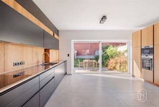 Découvrez cette magnifique maison familiale alliant confort moderne, finitions haut de gamme et excellente performance énergétique. Pensée pour répondre aux attentes des familles d'aujourd'hui, cette propriété offre des espaces généreux, une luminosité remarquable et des matériaux de qualité.Dès l'entrée, vous serez séduit par un hall accueillant menant à une vaste pièce de vie. La cuisine ouverte, signée Leicht, constitue un véritable espace de convivialité. Entièrement équipée, elle se distingue par son plan de travail en inox, ses nombreux rangements, sa taque de cuisson, son four ainsi que ses portes de placards motorisées. L'ensemble s'ouvre harmonieusement sur la terrasse et le jardin.Le rez-de-chaussée comprend également un garage avec porte sectionnelle, une buanderie entièrement aménagée offrant une agréable vue sur le jardin, ainsi qu'un WC indépendant.À l'étage, le hall de nuit dessert trois belles chambres, un dressing entièrement aménagé ainsi qu'une salle de bains équipée d'une baignoire en Corian, d'une douche, d'un meuble vasque, d'un WC et d'une VMC.Au deuxième étage, vous trouverez un vaste espace polyvalent. Celui-ci peut aisément accueillir une quatrième chambre de très belle superficie ou être réaménagé afin de créer deux pièces distinctes, permettant ainsi l'aménagement d'une cinquième chambre selon vos besoins.Cette habitation bénéficie de matériaux nobles tels que des tuiles flamandes, des briques rustiques et des gouttières en cuivre.
