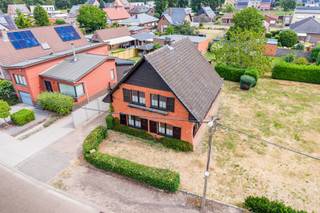 <p>Ruime gezinswoning met renovatiepotentieel op een mooi perceel. <br />Rustig gelegen in een aangename woonwijk, op korte afstand van het dorpscentrum.</p>
<p><strong>INDELING</strong></p>
<p><span>Gelijkvloers</span><br />De inkomhal vormt de centrale toegang tot de woning en leidt enerzijds naar de lichtrijke woonkamer met houtkachel en anderzijds naar de ruime leefkeuken.</p>
<p>De keuken is functioneel ingericht met een elektrisch kookvuur, dampkap en koelkast.</p>
<p>Vanuit de keuken zijn de kelder, de badkamer en het toilet bereikbaar.</p>
<p>Aansluitend bevindt zich een royaal overdekt terras, waar je geniet van het uitzicht op de achterliggende tuin.</p>
<p><span>Verdieping</span><br />Op de verdieping bevinden zich 4 volwaardige slaapkamers en een apart toilet.</p>
<p><span>Kelder/Zolder</span><br />De woning is deels onderkelderd en deels voorzien van een kruipkelder. <br />De zolder is bereikbaar via een vlizotrap.</p>
<p><span>Tuin</span><br />De tuin heeft een volwassen begroeiing dewelke zorgt voor een groen en natuurlijk kader, terwijl de tuin momenteel relatief weinig onderhoud vraagt. Achteraan bevindt zich een tuinberging en een serre.</p>
<p>Een garage voor 1 wagen is aangebouwd aan de woning.<br />Daarnaast biedt de oprit vlot plaats aan 2 extra wagens.</p>
<p>Kortom, een karaktervolle woning die klaar is voor renovatie, maar dankzij haar ruime vertrekken, aangename perceel en sterke ligging bijzonder veel mogelijkheden biedt.</p>
<p>BIJZONDERHEDEN<br />- houten schrijnwerk met handbediende houten luiken<br />- hoogrendementsglas (2018)<br />- verwarming op gas met condenserende ketel (2016)<br />- dak geïsoleerd (2020)<br />- elektriciteit niet conform<br />- EPC label E (406 kWh/m² jaar)</p>
<p>POSITIEVE ASPECTEN<br />- ruime en lichtrijke vertrekken<br />- tal van renovatie- en inrichtingsmogelijkheden<br />- rustig gelegen en toch vlak bij de dorpskern<br />- karaktervolle woning met veel potentieel</p>
<p><em>Stedenbouwkundige inlichtingen in aanvraag</em></p>