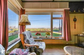 Op zoek naar een landelijk gelegen bungalow op een toplocatie? Zoek niet verder. Mits de nodige renovatie tover je hier je droomwoning met weids uitzicht op de velden. De woning is gelegen in een rustige doodlopende straat, op een mooi perceel van 420m2 en geniet zowel voor- als achteraan van een open zicht op de velden. Via de inkomhal komen we in de ruime woonkamer met aansluitend de keuken en wasplaats/berging. Verder zijn er twee slaapkamers, een badkamer met lavabomeubel, douche, en toilet. Mits verdere afwerking kunnen extra kamers gemaakt worden op zolder. In de tuin vinden we een garage en tuinhuis. Hier woon je heerlijk rustig, weg van de drukte, maar toch met alles binnen handbereik. Laat deze kans niet voorbijgaan en plan vandaag nog je bezoek in!
