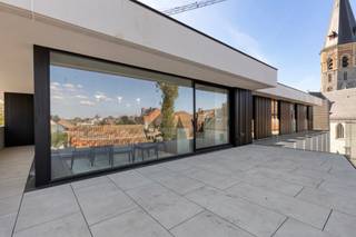 <p><strong>2 slaapkamer appartement in het prestigieus nieuwbouwproject “The Ensemble” in het hart van Assenede, waar stijl en comfort samenkomen in een unieke, karaktervolle omgeving.</strong><br /><br /><strong>Indeling<br /></strong>Men komt meteen uit in een hal met <strong>ingemaakte kasten</strong>, die toegang biedt tot alle ruimtes van het appartement.<br />In de hal bevindt zich een discreet geïntegreerde deur naar de berging, waar naast de technische installaties ook ruimte is voorzien voor wasmachine, droogkast en eventueel een extra koelkast en/of diepvries. De leefruimte met volledig geïnstalleerde open keuken geniet van een <strong>uitzonderlijk</strong> <strong>ruim terras.</strong><br />Via de hal vindt men het apart gastentoilet terug, gevolgd door de<strong> badkamer </strong>met inloopdouche en dubbele lavabo. Verder zijn er twee slaapkamers. <strong>Beide slaapkamers zijn voorzien van ingemaakte kasten.</strong><br /><strong><br />Bijzonderheden:<br /></strong>Energielabel <strong>A</strong>;<br />Maandelijkse kosten: 50,- EUR / maand <em>[verbruik/onderhoud van de gemeenschappelijke delen (incl. lift)]</em><br />Optioneel bij te huren: een <strong>ondergrondse autostaanplaats</strong> en een <strong>kelderberging:</strong> 100,- EUR per maand.<strong><br /><br />Ligging:<br /></strong>“The Ensemble” is uitstekend gelegen op de Markt van Assenede, in de Stadhuisstraat, pal naast het stadhuis en met een prachtig zicht op de kerk. U geniet hier van een centrale ligging met alle voorzieningen, winkels en horeca op wandelafstand, terwijl u tegelijkertijd woont in een charmante en sfeervolle omgeving.</p>