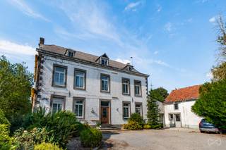 Idéalement implantée en recul de rue, cette maison de caractère de 443 m² habitables impose immédiatement sa prestance sur une magnifique parcelle de plus de 35 ares.<br /><br />Dès l'entrée, le ton est donné : un hall d'entrée absolument magnifique vous accueille, mettant en valeur des matériaux nobles comme le bois, témoins d'un charme d'antan préservé et à sublimer. L'ensemble de la maison bénéficie d'une belle hauteur sous plafond de 3 mètres, renforçant encore cette impression d'espace et de volume. La maison est par ailleurs très lumineuse.<br />Elle compte pas moins de 7 chambres ainsi que des bureaux, offrant un potentiel d'aménagement remarquable. Les multiples annexes latérales disposent d'un accès totalement indépendant, idéal pour l'exercice d'une profession libérale, avec déjà une arrivée d'eau et d'électricité sur place.<br />À l'étage, un grenier aménageable vient compléter les volumes disponibles.<br /><br />Une partie de l'électricité a déjà été revue, mais une rénovation totale reste à prévoir sur l'ensemble du bien — de quoi laisser libre cours à toute votre imagination pour façonner une propriété entièrement à votre image.<br /><br />Un bien rare, à découvrir absolument pour les amoureux de volume, de caractère et de projets ambitieux.<br /><br />PEB G - 302 793kWh/an - 657 kWh/m2.an - 20260731047150.<br /><br />***** Pour recevoir d'autres opportunités en exclusivité, nous vous invitons à nous contacter directement. Nous sommes disponibles pour vous accompagner dans votre recherche d'achat ou d'investissement ainsi que dans votre projet de vente. Pour toute demande d'évaluation GRATUITE et SANS ENGAGEMENT, contactez votre expert au 0483/42.84.59. *****