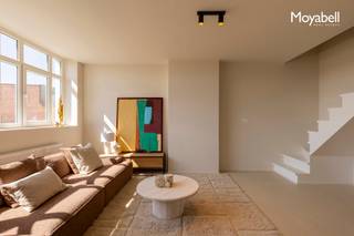 PRADO PENTHOUSE biedt een unieke woonervaring midden in het historische hart van Gent, op slechts 300 meter van de Kouter. Dit luxueuze appartement van 160 m² bevindt zich in een karaktervol gebouw uit 1925, opgetrokken in neoclassicistische stijl, waar authentieke elementen naadloos samensmelten met hedendaags comfort en functionaliteit. De op maat ontworpen keuken met kookeiland is afgewerkt in mortex en Calacatta Oro-marmer, en sluit perfect aan op de doorlopende mortexvloer die de volledige benedenverdieping siert. De ruime, lichtrijke leefruimte beschikt over een aansluitende eetplaats en een extra kamer die kan dienen als slaapkamer of bureau. , ideaal voor wie wonen en werken stijlvol wil combineren. Achteraan bevindt zich nog een 2 de slaapkamer met eigen badkamer en een groot zonnig terras met een prachtig zicht op de skyline van Gent. Op de bovenverdieping vind je de master bedroom met visgraag parket , dressing, een apart toilet, een tweede terras en een ruime badkamer uitgerust met inloopdouche, ligbad en dubbele lavabo. Het pand is toegankelijk via een privatieve lift of via een authentieke traphal in art - deco stijl. Ideaal voor wie op zoek is naar rust, luxe en comfort, midden in de bruisende stad. EPC B.