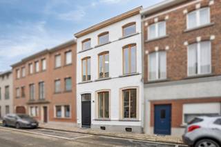 <p><span>In de statige Delportestraat, midden in het centrum van Tienen, bevindt zich deze karaktervolle herenwoning die in 2026 volledig werd gerenoveerd. Met drie slaapkamers, twee badkamers, een dressing, royale plafondhoogtes en EPC-label A combineert ze authentieke charme met het comfort van vandaag.</span></p>
<p><strong><span>Indeling</span></strong></p>
<p><span>Via de ruime inkomhal met vestiaire, gastentoilet en afzonderlijke wasplaats betreden we het gelijkvloers, waar de grote ramen en plafondhoogtes van meer dan drie meter voor een bijzonder ruimtelijk gevoel zorgen. Aan de voorzijde bevindt zich de leefruimte met parketvloer, terwijl de leefkeuken achteraan rechtstreeks aansluit op de onderhoudsvriendelijke stadstuin.</span></p>
<p><span>De keuken werd afgewerkt met grootformaattegels (90 × 90 cm) en beschikt over een composiet werkblad, hoogwaardige inbouwtoestellen en een wijnkoeler. De brede glaspartij zorgt voor een overvloed aan natuurlijk licht en kan voor twee derde worden opengeschoven, waardoor binnen en buiten op zonnige dagen naadloos in elkaar overlopen.</span></p>
<p><span>De eerste verdieping omvat een ruime slaapkamer met dressing, een badkamer met ligbad en douche en een apart toilet. De dressing is ruim genoeg om eventueel dienst te doen als extra kinderkamer of bureau. Op de tweede verdieping bevinden zich twee bijkomende slaapkamers met zicht op de authentieke dakbalken, evenals een tweede badkamer met douche en toilet. </span></p>
<p><span>De droge kelder biedt bijkomende bergruimte. De aanwezige verlichting zal blijven hangen en is inbegrepen in de verkoopprijs.</span></p>
<p><strong><span>Energie en comfort</span></strong></p>
<p><span>Bij de totaalrenovatie werd veel aandacht besteed aan energiezuinigheid, met onder meer bijkomende isolatie, driedubbele beglazing, vloerverwarming op het gelijkvloers en acht zonnepanelen (3.720 Wp). Het resultaat is een uitstekend EPC-label A, met een energiescore van slechts 68 kWh/m² per jaar.</span></p>
<p><strong><span>Omgeving</span></strong></p>
<p><span>De Leuvensestraat, een van de voornaamste winkelstraten van Tienen, ligt op amper 100 meter. Ook het station bevindt zich op slechts vijf minuten wandelen. Winkels, horeca en andere dagelijkse voorzieningen liggen met andere woorden binnen handbereik.</span></p>
<p><span>Tot slot is er de mogelijkheid om een autostaanplaats in de Delportestraat afzonderlijk te huren voor €68 per maand. De verkopers voorzien in de overdracht van het huurcontract aan de koper.</span></p>
<p><strong><span>Ontdek deze instapklare herenwoning tijdens een bezoek.</span></strong><span> Contacteer Jonas van Dhumas via 0491 29 53 92 of </span><span>jonas@dhumas.be</span><span>.</span></p>