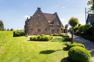 Bent u op zoek naar een instapklare villa op een strategische ligging in Groot-Bijgaarden? Dan stellen wij u graag deze charmante, landelijke woning (bouwjaar 1985) voor, gelegen op een prachtig perceel van 19 are op <strong>Hoogveld 29</strong>.<br />De woning geniet van een uitstekende bereikbaarheid: winkels, scholen, openbaar vervoer en het station van Dilbeek bevinden zich op wandelafstand. Met de wagen bereikt u vlot het centrum van Dilbeek, Ternat en de op- en afritten van de E40.<br /><br />Kortom, de ideale woning voor wie ruimte, rust en een centrale ligging wil combineren.<br /><br /><span>Indeling</span><br /><br />Via de ruime inkomhal met ingemaakte kasten, gastentoilet en een aparte bureauruimte betreden we de woning. Aansluitend bevindt zich de indrukwekkende woon- en eetkamer van maar liefst 62 m², met een plafondhoogte van 6 meter in de leefruimte, wat zorgt voor een bijzonder ruimtelijk gevoel.<br /><br />De ruime leefkeuken is volledig uitgerust en afgewerkt met kwalitatieve materialen. Vanuit de keuken heeft u directe toegang tot de pergola en het zonnige terras van 75 m², dat geniet van optimale privacy en een gunstige zuidoriëntatie.<br /><br />Op het eerste verdiep bevinden zich drie ruime slaapkamers (18 m², 19 m² en 12 m²), een badkamer met ligbad, een aparte douchekamer en een afzonderlijk toilet. De mezzanine vormt hier een absolute meerwaarde en creëert een mooie open verbinding met de woonkamer.<br /><br />De tweede verdieping (zolderverdieping) van maar liefst 58 m² is ingericht als een zeer ruime zolderkamer met sanitaire voorzieningen en bijkomende zolderruimte.<br /><br />Daarnaast beschikt de woning over een ruime kelder en een garage voor twee wagens. Boven de garage bevindt zich nog een polyvalente ruimte met douche, ideaal als hobbyruimte, bureau of extra slaapkamer.<br /><br /><span>Troeven: </span>EPC B – nieuwe ramen – elektriciteit conform – nieuwe verwarmingsketel op aardgas (2025) <br /><br />Is dit de droomwoning voor u en uw gezin? Contacteer ons vandaag nog voor een bezoek ter plaatse!<br /><br /><strong>02 887 80 56 - info@impromove.be</strong>