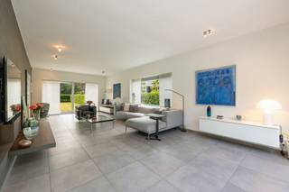 GELIJKVLOERSInkomhal 13m² op tegel met gastentoilet en handenwasser.Bureel 10m² op parket met kastenwand.Woonkamer 40m² op tegel met vast tv-meubel...