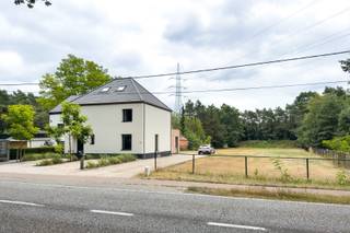 Ruim wonen, vlot bereikbaar zijn én binnen enkele minuten tussen de bossen staan? Aan de Kiezelweg in Mol hoef je gelukkig niet te kiezen.<br /><br />Deze vrijstaande woning werd in 2021 van A tot Z gerenoveerd door een aannemer en kreeg een frisse, strak-klassieke uitstraling. Vooraan zorgen de wit geschilderde gevel, zwarte ramen en aangelegde voortuin voor een verzorgde eerste indruk. Parkeren kan op de twee aangelegde plaatsen én op de ruime oprit, waar minstens zes wagens terechtkunnen.<br /><br />Binnen kom je via de ruime inkomhal, waar de technieken netjes achter kastdeuren verdwenen zijn. Verder vind je hier een gastentoilet en toegang tot de open leefruimte.<br /><br />En die leefruimte is meteen het hart van de woning. Wonen, eten en koken vloeien hier mooi in elkaar over, met zachte tinten, warme houtaccenten en grote raampartijen op een zuidgerichte tuin.<br /><br />De keuken is volledig uitgerust met een inductiekookplaat, spoelbak, koelkast, vaatwasser, oven en microgolfoven. Het ruime kookeiland biedt vier zitplaatsen.<br /><br />Aansluitend ligt de praktische berging en wasruimte met een aparte achterinkom. Op het gelijkvloers bevindt zich ook een ruime badkamer met ligbad, douche en twee lavabo’s.<br />De eerste verdieping telt een grote master bedroom met ingerichte maatwerkdressing, een ruime kinderkamer, een tweede badkamer met douche en dubbele wastafel, en een apart toilet. Nog een verdieping hoger bereik je via de vaste trap een volledig afgewerkte, open zolderruimte.<br /><br />Buiten beschik je over een perceel van in totaal maar liefst 31,5 are. De voortuin en parkeerzones zijn al aangelegd; de grote achtertuin kan nog volledig naar eigen smaak worden ingericht.<br /><br />Ook technisch staat de woning sterk, met vloerverwarming op gas op het gelijkvloers, dubbele beglazing, een alarmsysteem met raam- en deursensoren en een laadpaal. Met een EPC-score van 111 kWh/m² behaalt de woning bovendien een mooi B-label.<br /><br />