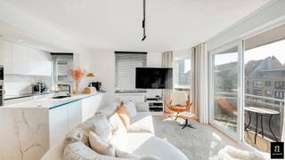 Cet appartement d'angle aménagé avec goût bénéficie d'une orientation sud sur la Graaf d'Ursellaan, récemment réaménagée, avec une vue dégagée sur la verdure et à deux pas de la plage. La Graaf d'Ursellaan est l'une des plus belles avenues de Heist, avec de jolies boutiques, des restaurants et à proximité de la célèbre Heldentoren. <br />En 2021, il a été entièrement rénové avec le souci du détail pour devenir un appartement confortable, alliant qualité et fonctionnalité. Le salon lumineux est entièrement orienté au sud et donne sur une agréable terrasse grâce à une baie vitrée coulissante. La belle cuisine ouverte blanche au look marbré est entièrement équipée d'appareils électroménagers modernes et d'une cheminée d'ambiance et constitue le cœur de l'espace de vie. Les deux chambres sont aménagées de manière pratique avec des armoires sur mesure et sont d'excellente qualité, tandis que la salle de bains avec baignoire-douche combinée offre un look contemporain et soigné. <br /><br />Grâce à son emplacement à quelques pas de la mer et des commerces, cet appartement allie l'esprit des vacances au confort quotidien. De plus, le bâtiment dispose d'une cave privée et d'un local à vélos commun facilement accessible, ce qui rend cette propriété encore plus attrayante.