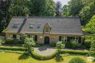 <p><span>Zeer stijlvolle en hoogwaardig afgewerkte villa gelegen in Kapellen-Bos, met o.a. een lichtrijke en ruime leefruimte, luxueuze leefkeuken met orangerie, 3 slaapkamers, 2 badkamers en een dubbele inpandige garage, op een zuidwestgericht perceel van ca. 4.577 m², voorzien van een fraai aangelegde tuin, verwarmd zwembad, meerdere terrassen en een eikenhouten bijgebouw met carport voor 3 wagens.</span></p><p><span> </span></p><p><span>INDELING</span></p><p><span>Gelijkvloers </span><span><br />Bij het binnenkomen betreedt u de inkomhal op tegelvloer, voorzien van een vestiaire en een gastentoilet met handenwasser. Via dubbele glazen stalen deuren bereikt u de sfeervolle cocktail room met ingemaakte kasten. Vanuit hier heeft u toegang tot de leefruimte, eveneens op tegelvloer, met ruime zit- en tv-hoek en een open haard. Aansluitend bevindt zich een verhoogde bureauruimte op parket, momenteel ingericht als speelruimte. Verder is er een kwalitatief ingerichte leefkeuken met ruim kookeiland en een prachtige orangerie waarin de eethoek is ondergebracht. Vanuit alle ruimtes op het gelijkvloers geniet u van een aangenaam zicht op het groen en de fraai aangelegde tuin. De keuken is voorzien van een ontbijthoek en alle ingebouwde toestellen, waaronder een spoelbak met Quooker kraan, inductiekookplaat met down-draft dampkap, wijnkoelkast, koelkast, combi-oven, stoomoven en vaatwasser. Aansluitend is er een bijkeuken met ingemaakte kasten, combi-microgolfoven, oven, ingebouwde vriezer, wasbak en voorzieningen voor wasmachine en droogkast op hoogte. Verder beschikt u over een dubbele inpandige garage.</span></p><p><span>Eerste verdieping</span><span><br />Via de houten trap bereikt u de nachthal. De master bedroom op parketvloer beschikt over ingemaakte kasten en een ensuite badkamer met dubbele regendouche en dubbele wastafel, aangevuld met een dressing. Daarnaast zijn er nog twee slaapkamers, eveneens op parketvloer, waarvan één met ingemaakte kasten. De tweede badkamer is voorzien van een ligbad. Op deze verdieping is er ook een apart toilet.</span></p><p><span>Zolder </span><span><br />Via een vlizotrap in de nachthal heeft u toegang tot een ruime bergzolder over de volledige breedte van de woning. </span></p><p><span>Kelder </span><span><br />De woning is volledig onderkelderd d.m.v. kruipruimte. </span></p><p><span>Tuin</span><span><br />De villa is gelegen op een zuidwest geörienteerd perceel van ca. 4.577 m² met een unieke bomenstand en veel privacy. Via de ruime kasseioprijlaan bereikt u zowel het eikenhouten bijgebouw met carport voor drie wagens en tuinberging, als de dubbele inpandige garage. In het bijgebouw bevindt zich tevens de technische installatie van het zwembad. Achteraan geniet u van een ruim open terras, een overdekt houten terras en een fraai aangelegde tuin voorzien van een verwarmd zwembad met warmtepomp.</span></p><p><span>Bijzonderheden<br /></span><span>- Gelegen op een gegeerde locatie: tussen het centrum van Heide en Kapellen nabij scholen, winkels, openbaar vervoer,…</span></p><p><span>- Recent zeer stijlvol gerenoveerd met gebruik van hoogwaardige materialen </span></p><p><span>- EPC B-label, elektriciteit is conform en asbestveilig</span></p><p><span>- Ruime, zuidwest georiënteerde tuin met meerdere terrassen en een verwarmd zwembad met warmtepomp en solar deck </span></p><p><span>- Veel parkeergelegenheid dankzij ruime oprit, dubbele inpandige garage en carport voor 3 wagens </span></p><p><span>- 24 zonnepanelen met groenestroomcertificaten </span></p><p><span>- De oppervlakten zijn indicatief en gebaseerd op het EPC.</span></p><p><span> </span></p>
