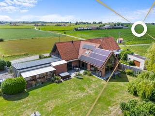 Te midden van de uitgestrekte velden bevindt zich deze uitzonderlijke eigendom waar rust en luxe samenkomen op een perceel van 11.187m². Dit historisch landgoed werd met oog voor detail gerenoveerd tot een instapklare parel, waar de combinatie van authentiek karakter en moderne architectuur zorgt voor een unieke woon- en belevingservaring. Dankzij de succesvolle B&B, de aanpalende herberg en de luxueuze privéwoning biedt dit domein bovendien een interessante opportuniteit voor wie op zoek is naar een levensproject met rendement. Het eigendom wordt beschouwt als "Handelshuis"<br /><br />De hoofdwoning charmeert met hoge plafonds, overvloedige glaspartijen en een lichtrijke leefruimte met zicht op de uitgestrekte tuin. De leefruimte sluit naadloos aan op een volledig uitgeruste keuken met keukeneiland. Een mezzanine met zicht op de tuin fungeert als bureau of hobbyruimte. De woning telt zes slaapkamers, waarvan vijf momenteel worden uitgebaat als volwaardige B&B-kamers met elk een eigen badkamer en toiletvoorziening. De master bedroom beschikt over een aparte dressing en een privé badkamer.<br /><br />Daarnaast is er een volledig uitgeruste wellnessruimte met hammam, infraroodsauna en jacuzzi en een ruim zonneterras dat grenst aan de perfect onderhouden tuin. De aanpalende herberg straalt authenticiteit uit en leent zich uitstekend voor evenementen of een horecazaak in combinatie met het gastenverblijf. <br /><br />Op technisch vlak is het geheel tot in de puntjes afgewerkt: vloerverwarming is per kamer regelbaar, het energieverbruik is optimaal dankzij een EPC-label A, 83 zonnepanelen, ongeveer 40 kW aan batterijopslag en een geothermische warmtepomp. Een ruime garage van 98 m² en zes extra parkeerplaatsen maken het eigendom compleet.<br /><br />Een uitzonderlijke eigendom die moeiteloos wonen en visie op de toekomst combineert — en dat alles in een groene omgeving.<br /><br />Contacteer ons nu voor een plaatsbezoek en ontdek zelf de charme van dit exclusieve eigendom!