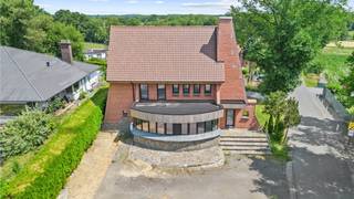 <p>Unieke kans in As: aan de Breëerweg 44 bevindt zich een ruime deels gerenoveerde woning die dankzij haar karakter en afmetingen tal van mogelijkheden biedt. Met een perceel van 6a 76ca en een bewoonbare oppervlakte van maar liefst 274 m² is dit pand uitermate geschikt om in te richten als gezinswoning, handelspand of een combinatie van beide. De brede voorgevel en de zichtbare ligging maken het ideaal voor wie wonen en werken wil combineren of voor wie een praktijk aan huis wenst, terwijl de royale leefruimtes zorgen voor een aangename en comfortabele woonervaring.</p>
<p>De ligging is een absolute troef: het pand bevindt zich op een centrale maar toch rustige locatie met een prachtig uitzicht op de achtergelegen velden. Alle voorzieningen zoals winkels, scholen, openbaar vervoer en de oprit van de autosnelweg zijn binnen handbereik. Binnenkomen doet u in een royale, open leefruimte met grote raampartijen die zorgen voor overvloedig natuurlijk licht. Achteraan is er ruimte voorzien voor een keuken met eetgedeelte die aansluit op de tuin en het terras, wat ideaal is voor wie houdt van een harmonie tussen binnen- en buitenleven. Op het gelijkvloers vindt u verder een badkamer, een apart toilet en een extra kamer die flexibel kan worden ingericht als bureau, praktijkruimte of handelsruimte.</p>
<p>Op de verdiepingen is er plaats in overvloed: zes slaapkamers in totaal, waaronder een master bedroom van maar liefst 30 m². Eén van de kamers geeft uit op een charmant terras aan de voorzijde, een fijne extra buitenruimte. Een tweede badkamer vervolledigt deze etage, waardoor de woning alles in huis heeft voor optimaal comfort.<br /><br />Ondergronds beschikt het pand over een kelder van 67 m², ideaal voor stockage of archief, en buiten is er een inpandige garage met elektrische poort voorzien, wat zowel praktisch als veilig is. De woning onderging reeds enkele renovaties en de elektrische installatie zal conform afgeleverd worden door de verkoper. De huidige EPC-score houdt rekening met het feit dat de vloeren nog niet geïsoleerd zijn en er nog geen centrale verwarming of sanitair geplaatst is. Dit biedt de koper de kans om te kiezen voor energie-efficiënte oplossingen op maat. Optioneel kan de verkoper de woning voorzien van vloerverwarming en vloerafwerking tegen een meerprijs van €16.000.</p>
<p>Met zijn royale afmetingen, uitstekende bereikbaarheid en de mogelijkheid om zowel privé als professioneel gebruik te combineren, is dit pand een zeldzame opportuniteit. Het pand is onderhevig aan de renovatieverplichting; meer informatie hierover vindt u via de website van de Vlaamse overheid<span></span>. Houd er rekening mee dat de bemeubelde foto’s digitale impressies zijn die het potentieel van dit pand illustreren.</p>