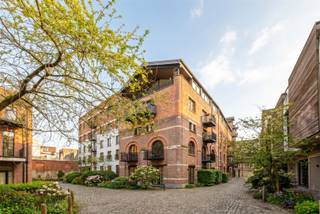<p>Welkom in Dorp in de Stad, een exclusief loftencomplex verscholen in een voormalig industrieel pakhuis, op wandelafstand van het Eilandje.<br />Deze unieke loft van 203 m² combineert rauwe industriële architectuur met een uitzonderlijk hoog afwerkingsniveau.</p><p>Dorp in de Stad bestaat uit drie gebouwen, slim gepositioneerd rond kasseien binnenplaatsen en verbonden door overbouwde doorgangen. Het rood baksteenmetselwerk in kruisverband en de authentieke pakhuisstructuur verwijzen naar het industriële verleden van eind 20e eeuw — vandaag vertaald naar een verfijnde, private woonbeleving.</p><p>• 2 slaapkamers & 2 badkamers<br />• Hoge plafonds en grote raampartijen<br />• Terras met panoramisch zicht over de stad<br />• Hoogwaardige afwerkinggraad</p><p>De riante leefruimte vormt het hart van de loft. Originele bakstenen muren en zichtbare staalstructuren bepalen de sfeer, terwijl het overvloedige daglicht en de hoge plafonds zorgen voor een indrukwekkend ruimtegevoel. Aansluitend bevindt zich het terras, met een wijds uitzicht over de oude stad — een ideale plek om te genieten van de avondzon. De open keuken is een statement op zich: afgewerkt in composiet en volledig uitgerust met hoogwaardige toestellen. Hier gaan design en functionaliteit perfect samen.</p><p>De master bedroom beschikt over ingemaakte kasten in walnootfineer en een luxueuze ensuite badkamer met inloopdouche, wastafel en toilet. De dressing werd uitgevoerd in gelakte palissander — verfijnd tot in het detail.<br />Op de mezzanineverdieping bevindt zich een 2e slaapkamer, aangevuld met een extra douchekamer.</p><p>Een loft waar industriële ziel en hedendaagse luxe elkaar versterken, midden in de stad en toch in alle privacy.</p><p>Ontdek deze uitzonderlijke loft nabij het Eilandje en plan uw bezoek via sinjoor.be</p>