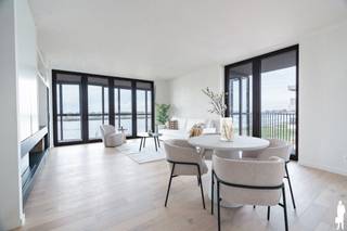 <h3>Exclusief wonen aan de Scheldekaaien met royale buitenruimtes</h3>
<p>Droomt u van een instapklaar, luxueus appartement op het bruisende Nieuw Zuid?<br />Dan zal deze parel met zicht op de Schelde u zeker weten te bekoren.</p>
<p><strong>Duurzaam, groen en stedelijk wonen</strong> – dat is waar de nieuwe wijk Nieuw Zuid in Antwerpen voor staat.</p>
<p>Op de vierde verdieping van de stijlvolle residentie <em>Zuiderhuis</em> ontdekt u een uitzonderlijk woonconcept dat elegantie en comfort combineert.</p>
<p>Wat dit appartement zo bijzonder maakt?<br />De prachtige wintertuin die grenst aan zowel de leefruimte als de slaapkamers. Deze ruimte vormt een natuurlijke verlenging van het interieur en laat u het hele jaar door genieten van licht, lucht en uitzicht. Vanaf het ruime terras geniet u van onvergetelijke zonsondergangen over de Schelde, terwijl het oostelijk georiënteerde terras uitnodigt om te ontbijten tussen het groen.</p>
<p>De open keuken met centraal kookeiland is ontworpen voor wie graag kookt en gezellig tafelt, rechtstreeks verbonden met het terras aan de oostzijde.</p>
<p>De hoofdslaapkamer beschikt over een luxueuze ensuite badkamer met inloopdouche, ligbad en dubbele wastafel.<br />De twee extra slaapkamers delen een tweede, volledig uitgeruste douchekamer.</p>
<p>Verder vindt u in de nachthal een apart gastentoilet en een praktische dressing.</p>
<p>Doorheen het volledige appartement werd gekozen voor hoogwaardige materialen en maatwerk. De ingebouwde kastwand met sfeervolle haard in de leefruimte vormt een echte blikvanger.</p>
<p>Bij de verkoop zijn <strong>vijf kelderbergingen</strong> inbegrepen.<br />Er is bovendien de mogelijkheid om <strong>vier autostaanplaatsen</strong> aan te kopen à <strong>€39.000 per stuk</strong>.</p>
<p>Verkoop onder <strong>BTW-stelsel</strong>.</p>