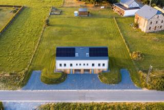In het hart van het dorp Saint-Ode, op enkele minuten van Bastogne, ontwikkelt dit recent gebouwde rijtjeshuis van ±180 m² een gezinsvriendelijke leefomgeving in een groene omgeving. De ruimtes, lichtinval en voorzieningen voldoen aan de verwachtingen van een eigentijdse, comfortabele en energiezuinige woning.<br /><br />Op de begane grond bevindt zich een mooie leefruimte met een volledig uitgeruste open keuken. Grote ramen verlengen de ruimtes naar het terras en de privétuin. Op de bovenverdieping bieden vier slaapkamers en twee badkamers een passende indeling voor het gezinsleven. Een garage met gemotoriseerde sectionaaldeur maakt het pand compleet.<br /><br />Op technisch vlak beschikt de woning over 12 fotovoltaïsche panelen, hoogwaardige PVC-kozijnen, leistenen dakbedekking, een alarmsysteem en afstandsbedieningen. De woning verkeert in uitstekende staat en vereist geen werkzaamheden. Winkels, scholen en wegen zijn gemakkelijk bereikbaar, met Bastogne op slechts enkele minuten afstand.