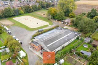 <p>In een groene en rustige omgeving, maar toch vlot bereikbaar, ligt dit bijzonder hippisch domein in Grimbergen, centraal in de Vlaamse rand ten noorden van Brussel. Dankzij de nabijheid van de ring rond Brussel en belangrijke verbindingswegen is deze locatie uitstekend geschikt voor zowel privégebruik als professionele paardenactiviteiten. Ondanks de centrale ligging ademt het domein rust en ruimte, precies wat paarden en ruiters nodig hebben, terwijl het tegelijk profiteert van de nabijheid van de grootstad.</p><p>Het eigendom heeft een oppervlakte van bijna 2ha  en is volledig vergund en ingericht voor een professionele hippische uitbating. Op het terrein bevinden zich 38 paardenstallen, ontworpen met aandacht voor comfort, hygiëne en praktisch gebruik. De infrastructuur omvat een binnenpiste van 20m x 40m en een buitenpiste van 35m x 75m met een modern eb- en vloedsysteem, waardoor trainen onder alle weersomstandigheden mogelijk blijft. Daarnaast zijn er meerdere weidepaddocks in hout omheind, een ruime parkeervoorziening en een gezellige cafetariaruimte met zicht op de binnenpiste. Voor extra comfort zijn er afzonderlijke sanitaire voorzieningen en een chalet uitgerust met fitnessruimte, badkamer en keuken.</p><p>Het geheel beschikt over een geldige milieuvergunning klasse 2 tot 2031 voor paardenfokkerij, verhuur van stallen en het organiseren van rijlessen. Dit biedt een veilige basis voor onmiddellijke voortzetting.</p><p>Voor wie extra ruimte of ontwikkelingsmogelijkheden zoekt, zijn er bijkomende percelen beschikbaar. Zo kan het domein worden uitgebreid met een aangrenzende weide van 74a 50ca (met aankoopoptie) en een bijkomende weide van 91a 22ca (met huuroptie). Bovendien bestaat de mogelijkheid om twee afzonderlijke woningen met bijgebouw,  waarin zich eveneens stallen bevinden,  aan te kopen. Deze percelen liggen in woongebied, wat de optie biedt om één of meerdere nieuwe woningen te realiseren in directe aansluiting met de paardenaccommodatie.</p><p>De combinatie van een strategische ligging, volledige infrastructuur en flexibele uitbreidingskansen maakt dit eigendom tot een uitzonderlijk aanbod in de regio. Het is een ideale keuze voor professionele uitbaters, gepassioneerde ruiters of investeerders die op zoek zijn naar een hippische eigendom waar wonen en werken samenkomen.</p>