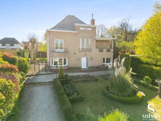 Ontdek de unieke charme van Villa Rozenberg, een karaktervolle woning uit circa 1936, gelegen in het hart van Zomergem op een uitzonderlijk perceel van maar liefst 2.150 m².<br /><br />Deze statige eigendom combineert authentieke elementen met hedendaags comfort en biedt tal van mogelijkheden dankzij de aanwezigheid van twee garages en een ruim magazijn van 70m², bereikbaar via een aparte oprijlaan langs de Kleitstraat.<br /><br />Bij het betreden van de woning word je verwelkomd in een indrukwekkende inkomhal die meteen de sfeer zet. Het gelijkvloers omvat een lichtrijke keuken, een gezellige leefruimte met haardvuur, een bureauruimte, een tweede knusse zithoek, evenals een praktische wasplaats/berging en een ruime, droge kelder.<br /><br />Op de eerste verdieping bevinden zich vier volwaardige slaapkamers en een ruime badkamer, uitgerust met inloopdouche, dubbele lavabo en toilet. De zolderverdieping biedt een prachtige vijfde slaapkamer met airco. Op deze verdieping werd ook een tweede badkamer gecreëerd met opnieuw een inloopdouche, dubbele lavabo en toilet. <br /><br />De zonnige, zuidwest georiënteerde tuin vormt een oase van rust, waar je in alle sereniteit kan genieten van het buitenleven. Daarnaast beschikt de tuin over een tuinhuis met overkapping en een gezellige ontspanningsruimte.<br /><br />Villa Rozenberg is een zeldzame opportuniteit voor wie op zoek is naar ruimte, karakter en een centrale ligging, gecombineerd met tal van mogelijkheden voor wonen en werken.