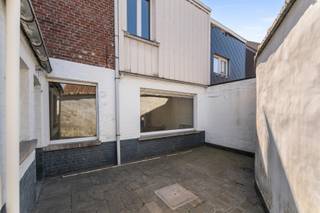 Ruime, te renoveren woning in het volle stadscentrum in de directe omgeving van winkels, scholen, openbaar vervoer.... alles op wandelafstand!<br /><br />Deze rijwoning met een koer/terras van ca 20 m² heeft een ruime bewoonbare oppervlakte: in 1981 werden twee woningen tot één woning samengevoegd. <br /><br />Huidige INDELING van de woning: <br /><br />GELIJKVLOERS: inkom met vestiaire en toilet, leefruimte, keuken met ontbijthoek en toegang tot de koer. Vanuit de keuken is ook de voorraadkelder toegankelijk en de aparte berging/wasplaats. <br /><br />VERDIEPING: 3 ruime slaapkamers en badkamer (toilet, lavabo en ligbad)<br /><br />Er is een VASTE TRAP naar een hoge ZOLDERRUIMTE die bijkomend kan worden ingericht.
