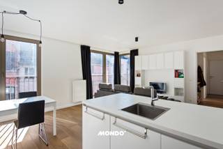 Op de eerste verdieping van dit recente appartementsgebouw (bouwjaar 2022) bevindt zich dit energiezuinige en perfect instapklare appartement. Een ideale woonst voor wie comfort, licht en modern woonplezier zoekt.<br />Via de inkomhal betreed je het appartement. Aan de linkerzijde kom je in de ruime en lichtrijke leefruimte met gezellige living, eetplaats en een open, volledig geïntegreerde keuken. Aansluitend is er een praktische berging, ideaal voor extra opslagruimte en perfect geschikt als was- en droogruimte.<br /><br />Een absolute troef is het zuidgericht terras, dat toegankelijk is vanuit de leefruimte én beide volwaardige slaapkamers. Hier geniet je de hele dag van zon en rust. Ideaal om te ontspannen of gezellig te tafelen.<br /><br />Verder beschikt het appartement over:<br />- 2 volwaardige slaapkamers<br />- Een apart gastentoilet<br />- Een moderne badkamer met dubbele lavabo en inloopdouche<br />- Een extra aparte berging voor bijkomende opslag<br /><br />Dankzij de recente bouw en de doordachte, praktische indeling geniet je hier van hedendaags wooncomfort in een energiezuinige setting.<br /><br />Interesse? Maak snel een afspraak en kom zelf de sfeer en het comfort van dit appartement ervaren tijdens een bezoekmoment.<br /><br />Contacteer: Marte Van Damme <br />marte@mondovastgoed.be<br />tel: 0498 40 40 50