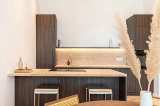Stel je voor: wonen in het hart van de stad, op een steenworp van alles wat je nodig hebt, in een fris gerenoveerd appartement. Dit appartement, gelegen op de eerste verdieping van een kleinschalig gebouw, biedt 81m² aan woonplezier en comfort.

Zodra je de deur opent, word je verwelkomd door een prachtige visgraatparketvloer die door het hele appartement loopt. De grote raampartijen met charmante Franse balkons zijn echte blikvangers; ze zorgen niet alleen voor een overvloed aan natuurlijk licht, maar ook voor een levendig uitzicht op de karaktervolle stadsarchitectuur. De open leefruimte stroomt moeiteloos over in de moderne keuken met donkere kasten en lichte werkbladen, de ideale plek om te koken terwijl je vrienden alvast een wijntje inschenken.

Slim ingedeeld, beschikt het appartement over een royale master bedroom waar rust de boventoon voert. De tweede kamer is compact maar functioneel, perfect als rustige bureau-ruimte voor de thuiswerker of als fijne logeerkamer. De badkamer is modern afgewerkt met een ruime inloopdouche en een dubbele wastafel, perfect voor een frisse start van de dag. Verder beschikt het appartement ook over een aparte toilet. Dankzij de recente renovatie is dit appartement volledig instapklaar en wacht het gewoon op jouw meubels.

In de kelder is er een private berging beschikbaar.

Zin om dit lichte en sfeervolle appartement met eigen ogen te ontdekken? Maak snel een afspraak via info@goose.be of +32 479 75 91 36.