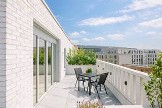<p><span>GENT - Uniek penthouse met panoramisch terras in groene stadsontwikkeling nabij het centrum</span></p><p><span> </span></p><p><span>Op de bovenste verdieping van Residentie Artevelde (2023) bevindt zich dit ruime en energiezuinige penthouse met uitzonderlijke terrassen van ca. 113m². De combinatie van royale terrassen, grote raampartijen, hedendaagse architectuur en een groene ligging, maken dit appartement een uitzonderlijke opportuniteit met hoge mate van privacy en een unieke buitenbeleving.</span></p><p><span> </span></p><p><span>Het penthouse maakt deel uit van de Tondeliersite, een moderne stadsontwikkeling waar wonen, duurzaamheid en community centraal staan. De site bevindt zich op korte afstand van het centrum van Gent in een autoluwe woonomgeving en geniet daarnaast van een prachtige groene ruimte, voorzieningen en vlotte verbindingen.</span></p><p><span> </span></p><p><span>De belangrijkste troeven </span></p><ul><li><span>Panoramische vergezichten op het Tondelierpark en de stad</span></li><li><span>Nieuwbouwresidentie uit 2023</span></li><li><span>Top floor: vierde en bovenste verdieping</span></li><li><span>Royale terrassen van ca. 113m² met verschillende oriëntaties</span></li><li><span>Flexibele indeling: mogelijkheid om een extra kamer te creëren</span></li><li><span>Grote raampartijen, hoge plafonds en parketvloeren</span></li><li><span>Voorzien van moderne en energiezuinige technieken (BEN): airconditioning op warmtepomp, zonnescreens en zonnepanelen</span></li><li><span>Lage energiekosten: vloerverwarming via warmtenet</span></li><li><span>Luxueuze inbouwkeuken met massieve natuursteen en Miele-toestellen</span></li><li><span>Ondergrondse staanplaats en individuele laadpaal</span></li><li><span>Gemeenschappelijke fietsenberging met drie gereserveerde plaatsen</span></li><li><span>Gemeenschappelijke leefruimte met keuken en sanitair voor de bewoners van het gebouw, gelegen op het gelijkvloers</span></li></ul><p><span> </span></p><p><span>De indeling</span></p><p><span>Het penthouse is gelegen op de vierde en bovenste verdieping en is bereikbaar via de lift. De inkomhal beschikt over een apart gastentoilet en de mogelijkheid tot het plaatsen van een vestiairekast.</span></p><p><span> </span></p><p><span>Via een stalen deur bereikt u de ruime en lichtrijke leefruimte. De grote raampartijen en hoge plafonds zorgen voor een aangenaam ruimtegevoel. Vanuit de leefruimte is er rechtstreekse toegang tot het hoofdterras van ca. 85m², dat een prachtig zicht biedt over het park en de Gentse skyline. De open keuken is uitgerust met kwalitatieve toestellen van Miele. Aansluitend bevindt zich een praktische berging met aansluiting voor wasmachine en droogkast. Het bijkomende terras van ca. 26m² is toegankelijk via de keuken.</span></p><p><span> </span></p><p><span>Via de nachthal komen we aan in de eerste slaapkamer die beschikt over bijkomende kastruimte en een eigen badkamer met douche en lavabomeubel. De tweede slaapkamer geniet van een prachtige lichtinval en beschikt daarnaast over een aparte tweede badkamer en toegang tot beide terrassen.</span></p><p><span> </span></p><p><span>De huidige indeling biedt bovendien de mogelijkheid om een derde kamer te creëren. Deze kan worden ingericht als bureauruimte of als extra slaap- of logeerkamer.</span></p><p><span>Bij het penthouse horen drie exclusief gereserveerde plaatsen in de gemeenschappelijke fietsenberging. Daarnaast is er een ondergrondse autostaanplaats met laadpaal beschikbaar.</span></p><p><span> </span></p><p><span> </span></p><p><span>Over de Tondeliersite</span></p><p><span>De Tondeliersite vormt een nieuwe en duurzame stadswijk nabij het centrum van Gent. De ontwikkeling combineert woningen en appartementen met groene publieke ruimte en gemeenschappelijke voorzieningen. De gemeenschappelijke leefruimte in het gebouw versterkt het community-gerichte karakter van de site en biedt bewoners bijkomende ruimte voor ontmoeting en gedeeld gebruik.</span></p><p><span> </span></p><p><span>Belangrijk</span></p><p><span>Richtprijs penthouse: 898.000 EUR</span></p><p><span>Richtprijs staanplaats: 50.000 EUR</span></p><p><span>EPB Label A: 41 kWh/m² jaar (E21)</span></p><p><span> </span></p><p><span>Benieuwd? Contacteer Axel Lenaerts makelaars voor meer info of een bezoek via <span>Laurens@axellenaerts.be</span></span><span> of 09 245 24 24</span></p><p><span> </span></p>