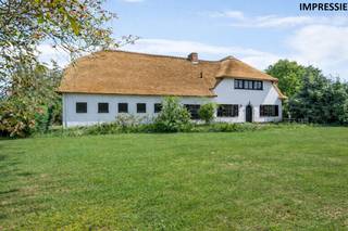 In een doodlopende en bijzonder rustige villawijk, bevindt zich deze riante hoeve op een prachtig perceel van ca. 2.950 m². De ligging is ideaal voor wie rust en ruimte zoekt, maar toch vlot bereikbaar wil wonen: op korte afstand van het centrum van Schilde en Oelegem, het Albertkanaal en de oprit van de E34. Een uitzonderlijke locatie met veel groen, privacy en mogelijkheden.<br /><br />Met een straatbreedte van meer dan 80 meter biedt dit perceel, mits afbraak van het bijgebouw en/of de hoeve, interessante verkavelingsmogelijkheden. Het grote bijgebouw, voorheen deels in gebruik als stallen en nu als opslag, vormt bovendien een enorme troef voor wie nood heeft aan extra ruimte voor een praktijk, kantoor, atelier, zorgwonen of stockage. Ook de inpandige garage met grote zolderruimte biedt verrassend veel potentieel.<br /><br />Via de inkomhal met vestiaire en gastentoilet betreedt men de woning. De ruime woonkamer met authentieke open haard sluit naadloos aan op de eetkamer. De leefkeuken heeft onmiddellijk toegang tot de voorraadkelder en de traphal, en grenst aan een tussenruimte die dienst kan doen als bureau of bijkeuken. Vanuit deze ruimte is er toegang tot de indrukwekkende inpandige garage van ca. 75 m², waar zich een wasplaats met toilet en douche bevindt. Een trap leidt ernaar een ruime zolder, ideaal voor het creëren van extra kamers of een hobbyruimte.<br />Op de eerste verdieping biedt een centrale overloop toegang tot vier ruime slaapkamers en een badkamer ingericht met ligbad, dubbele wastafel, bidet en toilet. De woning beschikt bovendien over een praktische kelder.<br /><br />De tuin strekt zich rondom de gebouwen uit en omvat een royale oprit, een zonnige tuin en een achterliggende speelweide. Dankzij de enorme breedte en oppervlakte van het perceel zijn hier diverse toekomstige mogelijkheden denkbaar, zowel voor particulier gebruik als voor ontwikkeling.<br /><br />De bewoonbare oppervlakte bedraagt 221 m², exclusief zolder en garage. Wanneer deze ruimtes worden meegerekend, biedt de woning meer dan 400 m² aan bruikbare oppervlakte.<br /><br /><strong>Bijzonderheden</strong><br /><strong>+ Uitzonderlijk perceel van ca. 2.950 m²</strong><br /><strong>+ Straatbreedte van meer dan 80 meter met verkavelingspotentieel</strong><br /><strong>+ Inpandige garage van ca. 75 m² met zolderruimte</strong><br /><strong>+ Groot vrijstaand bijgebouw met tal van mogelijkheden</strong><br /><strong>+ Rustige ligging in een doodlopende villawijk nabij E34 en centrum</strong>