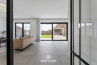 Voor meer info en foto’s, surf naar www.swevers.be – In een rustige woonomgeving in Leopoldsburg bevindt zich deze indrukwekkende open bebouwing uit 2020. Deze instapklare BEN-villa combineert hedendaagse architectuur met ruimte, comfort en een hoogwaardige afwerking. Met een bewoonbare oppervlakte van 298 m² en een perceel van 8a 26ca biedt deze woning een aangename woonbeleving met veel natuurlijk licht dankzij de grote raampartijen. Via de inkomhal betreedt u het gelijkvloers met gastentoilet en een praktische bureauruimte, ideaal voor thuiswerk. De ruime leefruimte van circa 50 m² vormt het hart van de woning en biedt plaats voor een gezellige zithoek en eetruimte. Aansluitend bevindt zich de moderne keuken van ongeveer 24 m² met kookeiland, perfect voor wie graag kookt en gasten ontvangt. Verder zijn er op dit niveau een berging en extra bergruimte aanwezig. De eerste verdieping is ingericht als slaapverdieping met vier ruime slaapkamers van ongeveer 18 m², 20 m², 22 m² en 22,5 m². Daarnaast zijn er twee badkamers en een aparte dressing voorzien, wat extra comfort biedt voor een gezin. Op de tweede verdieping bevindt zich een vijfde slaapkamer van circa 22,5 m², ideaal als logeerkamer, hobbyruimte of bureau, samen met een praktische wasruimte. Rondom de woning ligt een aangename tuin waar u in alle rust kan genieten van het buitenleven. De open bebouwing zorgt voor een ruimtelijk gevoel en extra privacy. Verder beschikt de woning over een garage. Ook de ligging is bijzonder gunstig: scholen op 120 meter, openbaar vervoer op 160 meter en winkels, restaurants en ontspanning op ongeveer 200 meter. De snelwegen zijn bereikbaar op 7,5 km. Voor meer informatie, bel 011 255 155. Bron bewoonbare oppervlakte: EPC – verslag.