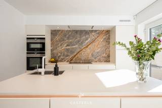 Wonen in een strakke, hedendaagse BEN-woning in een kindvriendelijke en uiterst praktische omgeving in Wondelgem? Deze halfopen bebouwing, gebouwd in 2020, combineert hedendaagse architectuur met hoogwaardige materialen, doordacht maatwerk en een bijzonder aangenaam wooncomfort.<br /><br />Achter de strakke witte gevel, gecombineerd met warme houten accenten aan de gevel en garagepoort, schuilt een instapklare gezinswoning waar functionaliteit en esthetiek mooi in balans zijn.<br /><br />Karaktervolle leefkeuken<br />De open leefkeuken vormt het hart van de woning en is afgewerkt met hoogwaardige materialen. De indrukwekkende marmeren achterwand, een eiland met dubbele spoelbak en de discreet geïntegreerde designverlichting zorgen voor een eigentijdse en sfeervolle uitstraling. Een ideale ruimte om dagelijks te genieten, maar ook om familie en vrienden te ontvangen.<br /><br />Doordachte indeling en hoogwaardig maatwerk<br />Met een bewoonbare oppervlakte van 158 m² biedt de woning een bijzonder comfortabele en praktische indeling.<br />Op de verdieping bevinden zich drie slaapkamers. Eén van de kamers is momenteel ingericht als multifunctionele ruimte, met ingemaakte kasten, een bureau en een geïntegreerd 'verborgen' bed. Dankzij de slimme indeling en hoogwaardige afwerking kan deze ruimte zowel als volwaardige bureauruimte als slaapkamer of logeerkamer worden gebruikt. De aangename natuurlijke lichtinval maakt de kamer bovendien bijzonder geschikt als werk- of slaapruimte.<br /><br />De badkamer is afgewerkt met een eigentijdse inrichting en beschikt over een strakke inloopdouche en een elegant dubbel wastafelmeubel. De leidingen voor de plaatsing van een bad zijn reeds voorzien. Zowel op het gelijkvloers als op de verdieping is er een afzonderlijk gastentoilet.<br /><br />Doorheen de woning werd gekozen voor onderhoudsvriendelijke keramische vloeren in combinatie met vloerverwarming. Marmer- en eikaccenten, aangevuld met talrijke kamerhoge maatkasten, zorgen voor een rustige en kwalitatieve afwerking met een optimale benutting van de beschikbare ruimte.<br /><br />Exclusieve troeven op een rij<br />-Instapklaar<br />-Ingebouwde koffiecorner<br />-Verfijnd maatwerk en hoogwaardige materialen<br />-Vloerverwarming doorheen de woning<br />-Energiezuinige BEN-woning met zonnepanelen (thuisbatterij niet inbegrepen) en laadpaal<br />-Geïntegreerd alarmsysteem <br /><br />Achteraan geniet de woning van een aangenaam aangelegd terras en een onderhoudsvriendelijke tuin, omringd door groen. Het praktische tuinhuis biedt bijkomende bergruimte. De inpandige garage biedt plaats aan een wagen en fietsen en zorgt bovendien voor een rechtstreekse verbinding met de woning.<br /><br />Praktisch en rustig wonen in Wondelgem<br />De woning bevindt zich in Wondelgem, ten noordwesten van Gent, en geniet van een bijzonder praktische ligging. Een rustige, kindvriendelijke woonomgeving wordt hier gecombineerd met een vlotte bereikbaarheid van de belangrijkste invalswegen en het openbaar vervoer.<br /><br />Ook voor gezinnen is de ligging bijzonder interessant. Scholen zoals de Daltonschool (ca. 653 m) en basisschool Klimrek Van Belle (ca. 794 m) bevinden zich op korte wandel- of fietsafstand.<br /><br />Voor de dagelijkse voorzieningen hoeft u bovendien niet ver te gaan: een apotheek, huisarts, park, speeltuin en supermarkten zoals Colruyt en Carrefour Express bevinden zich allemaal binnen een straal van ongeveer 1 kilometer. Een uitzonderlijke, energiezuinige gezinswoning met hoogwaardige afwerking, veel maatwerk en een bijzonder praktische ligging in Wondelgem.