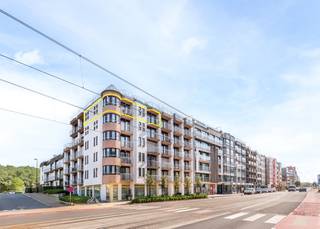 <strong>Uniek hoekappartement in hartje Oostduinkerke – uw droomverblijf aan de kust!</strong><br /><br />Geniet van ruim wonen op toplocatie! Dit stijlvol hoekappartement van maar liefst 96 m² bevindt zich op de vijfde verdieping van de kwalitatieve residentie Promenade (2003) – strategisch gelegen op de hoek van de Astridlaan en de Albert I Laan, pal in het bruisende commerciële centrum van Oostduinkerke.<br /><br />Of u nu op zoek bent naar een ruim en lichtrijk tweede verblijf of een vaste woonst aan zee: dit appartement biedt u alles wat u nodig heeft.<br /><br />Het appartement werd als volg ingedeeld: Ruime inkomhal | Lichtrijke leefruimte met volledig uitgeruste open keuken, uitgevend op balkon | eerste slaapkamer | Tweede ruime slaapkamer met ingebouwde kasten én toegang tot een tweede balkon | Afzonderlijk toilet | Badkamer met 2 lavabo's, een douche én een bad | Extra ruime berging met aansluiting voor wasmachine.<br /><br /><strong>Optie</strong>: privé-parkeerplaats in de residentie beschikbaar voor slechts € 35.000<br />Gemeenschappelijke fietsenberging aanwezig.<br /><br />Mis deze unieke kans niet en contacteer ons vandaag nog voor een bezichtiging!