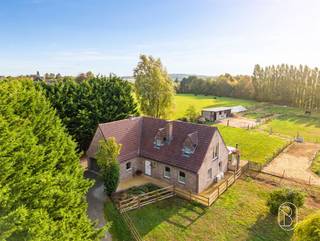 BEZOEKDAG 17/10/2026 14U30-17UPrachtige landelijke villa met 4 slaapkamers, dubbele garage en adembenemend uitzicht op 7.248 m²!In het prachtige, rurale Ellezelles bevindt zich deze ruime landelijke villa, verscholen in een ware oase van rust. Op een magnifiek perceel van maar liefst 7.248 m² geniet je hier elke dag van ruimte, privacy en een weids uitzicht over het glooiende landschap van het Pays des Collines. Een unieke plek voor wie droomt van landelijk wonen, omringd door groen en natuur!Indeling: ruime inkomhal, apart toilet met lavabo, royale woonkamer en een aangrenzende, landelijk ingerichte keuken voorzien van vaatwasser, kookfornuis, kookeiland en gezellig ontbijtmeubel. Vanuit de keuken bereik je de veranda, waar het prachtige uitzicht over de tuin volledig tot zijn recht komt en je rechtstreeks toegang hebt tot het terras.Verder beschikt het gelijkvloers over een praktische wasruimte, een slaapkamer en badkamer, waardoor gelijkvloers wonen perfect mogelijk is. De dubbele garage biedt bovendien alle ruimte voor wagens, fietsen en extra stockage.Op de eerste verdieping bevinden zich drie ruime slaapkamers, een tweede badkamer, een nachthal en een praktische zolderruimte. Met in totaal vijf slaapkamers en twee badkamers biedt deze villa bijzonder veel mogelijkheden voor een groot gezin, thuiswerk of het ontvangen van gasten. Bovendien is de woning volledig onderkelderd.Ook technisch is de woning uitgerust met het nodige comfort. De verwarming gebeurt via lucht-luchtwarmtepompen, aangevuld met pelletkachels in zowel de woonkamer als de veranda.Buiten is het vooral de uitzonderlijke ligging die meteen weet te overtuigen. Het royale perceel van 7.248 m², de rust en het prachtige vergezicht over het Pays des Collines creëren een uniek gevoel van vrijheid. De uitgestrekte buitenruimte biedt bovendien volop mogelijkheden voor tuinliefhebbers én voor wie droomt van het houden van dieren.Een karaktervolle villa op een uitzonderlijke locatie, waar ruimte, natuur en landelijk wonen samenkomen. Hier kom je thuis en geniet je elke dag opnieuw van rust en vrijheid!Te koop via Immo Beguin, jouw vastgoedexpert sinds 2009.