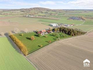 <p><strong>OVERNAME: Uniek eigendom in Dranouter (Heuvelland)</strong></p>

<p><strong>Over de woning:</strong></p>

<p>In het pittoreske Dranouter, deelgemeente van Heuvelland, ontdek je deze uitzonderlijke eigendom op een perceel van maar liefst 29.056 m². De voormalige hoeve werd in 2012 volledig heropgebouwd met oog voor duurzaamheid, comfort en detail. Alle gebouwen werden vergund en zijn onmiddellijk instapklaar.</p>

<p>De eigendom wordt momenteel uitgebaat als B&amp;amp;B en vakantiewoning en biedt tal van mogelijkheden voor wie op zoek is naar een combinatie van wonen en werken. Er zijn vijf stijlvolle gastenkamers, elk met een eigen badkamer, en een apart vakantiehuis dat geschikt is voor circa 8 personen.</p>

<p><strong>Indeling van de woning:</strong></p>

<ul><li>Vijf ingerichte gastenkamers met privébadkamer</li><li>Vakantiewoning voor 8 personen</li><li>Ruime loods van ca. 200 m², ideaal als opslag- of parkeerruimte</li><li>Diverse buitenruimtes waaronder een paardenomheining met gedraineerd systeem, een boszone, een fruitgaard en boomgaard</li></ul>

<p><strong>Energiezuinigheid:</strong></p>

<p>Dankzij de heropbouw in 2012 met gebruik van robuuste en duurzame materialen, is deze woning niet alleen kwalitatief en authentiek ingericht, maar ook energiezuinig en instapklaar.</p>

<p><strong>Troeven op een rijtje:</strong></p>

<ul><li>Perceel van ruim 29.000 m²</li><li>Instapklare gebouwen met vergunning en functiewijziging</li><li>Uitbating als B&amp;amp;B/vakantiewoning mogelijk</li><li>Stijlvolle afwerking met duurzame materialen</li><li>Uitzonderlijk uitzicht op het Heuvelland</li><li>Rustige ligging met zon de hele dag</li><li>Grote loods van ca. 200 m²</li><li>Bos, fruit- en boomgaard aanwezig</li><li>Paardenomheining met drainage</li></ul>

<p><strong><em>PRIJS: o.t.k.</em></strong></p>