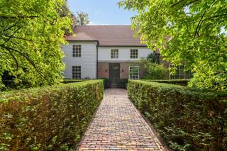 <p><span>Deze bijzonder ruime villa in Long Island-stijl is gelegen aan de Frilinglei, één van de meest gegeerde locaties van Brasschaat-Vriesdonk op een perceel van ca. 3.182 m²</span></p><p><span> </span></p><p><span>Indeling</span><span>: U betreedt de villa middels de ruime centrale inkomhal met vestiaire en gastentoilet. De natuurstenen vloer en brede zichtlijnen geven onmiddellijk een indruk van de royale volumes van de woning. Aan de voorzijde bevindt zich een afzonderlijke tv-kamer met maatwerkmeubilair. Aansluitend ligt de ruime woonkamer, welke werd ingericht met verschillende zitgedeeltes en een sfeervolle open haard. Grote raampartijen en schuifdeuren zorgen voor veel natuurlijk licht en geven rechtstreeks toegang tot de terrassen en tuin. De aansluitende eetkamer vormt een mooie verbinding tussen de woonkamer, ontbijtkamer en keuken. Ook hier zorgen de raampartijen voor een aangename relatie met het omliggende groen. De royale keuken werd ingericht met veel kastruimte en diverse inbouwtoestellen. Een afzonderlijke ontbijtkamer biedt ruimte voor dagelijks tafelen en geeft uit op het terras. Aansluitend bevinden zich een praktische bijkeuken en wasplaats.</span></p><p><span> </span></p><p><span>Inpandig zwembad</span><span>: Een bijzondere troef is het inpandige zwembad met grote raampartijen naar de tuin en vormt een private ontspanningsomgeving binnen de woning. Het inpandige zwembad werd nog niet gerenoveerd doch is functioneel. De afzonderlijke technische ruimte bevindt zich direct naast het zwembad en beschikt ook over een aparte toegangsdeur voor onderhoudspersoneel.</span></p><p><span> </span></p><p><span>Garages</span><span>: De villa beschikt over drie inpandige garages en een ruime, volledig verharde oprit met parkeergelegenheid voor meerdere wagens. Vanuit de garage heeft u toegang tot de kelder.</span></p><p><span> </span></p><p><span>Kelder</span><span>: De woning beschikt over een praktische kelder met bergruimte en wijnkelder. De villa is verder volledig voorzien van kruipruimte.</span></p><p><span> </span></p><p><span>Eerste verdieping</span><span>: De centrale trap leidt naar de ruime nachthal op de eerste verdieping. De royale mastersuite vormt een afzonderlijk en comfortabel geheel met een ruime slaapkamer, eigen dressing en een luxueus vernieuwde badkamer, stijlvol afgewerkt en ingericht met een vrijstaand ligbad, ruime inloopdouche, dubbele wastafel en toilet. Tevens een logeerkamer of bijkomende slaapkamer met eveneens een badkamer. Daarnaast bevinden zich op deze verdieping nog drie volwaardige slaapkamers en drie badkamers. De kamers beschikken over mooie volumes, natuurlijk lichtinval en diverse bergmogelijkheden. </span></p><p><span> </span></p><p><span>Tuin en buitenruimtes</span><span>: De villa wordt omgeven door een volwassen en bijzonder private tuin met uitgebreide tuinverlichting. De automatische toegangspoort, hoge hagen en volwassen bomen creëren een groen kader rondom de woning en waarborgen een hoge mate van rust en privacy. De tuin werd voorzien van een automatisch beregeningssysteem welke is aangesloten op een geboorde put van ca 70 meter diep. Aan de achterzijde zijn royale terrassen welke rechtstreeks aansluiten op de verschillende leefruimtes. De ruime oprit aan de zijkant van het eigendom biedt een discrete toegang tot de garages en bijkomende parkeergelegenheid.</span></p><p><span> </span></p><p><span>Bijzonderheden</span><span>: Deze villa werd gebouwd in 1988 door Vlassak-Verhulst met hoogwaardige en duurzame materialen en gerenoveerd in 2022. De woning biedt u royale leefruimtes, vijf slaapkamers, zes badkamers, een inpandig zwembad en drie garages en onderscheidt zich door haar Long Island-architectuur, bijzonder royale woonoppervlakte en flexibele indeling. Recent werden reeds verschillende renovatie- en opfrissingswerken uitgevoerd waarbij onder meer de volledige elektrische installatie werd vernieuwd, een uitgebreid KNX-domoticasysteem werd voorzien voor de intelligente aansturing van de woning, nieuwe toegangspoort en garagepoorten en werden de houten vloeren opnieuw geschuurd. Deze villa is een bijzonder eigendom op één van de mooiste locaties van Brasschaat-Vriesdonk.</span></p><p><span> </span></p><p><span>Meer inlichtingen via ons kantoor.</span></p>
