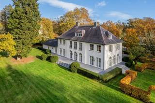 <p><span>Wonen in een groene oase zonder in te boeten aan comfort en bereikbaarheid. Ontdek deze karaktervolle, tijdloze en perfect onderhouden villa waar elegantie, licht en natuur harmonieus samenkomen. Dit eigendom onderscheidt zich door haar grote raampartijen die zorgen voor een zee van natuurlijk licht en een gevoel van openheid. Binnenstappen is thuiskomen in de grote en aangename leefruimtes, met zicht op de parktuin. De villa is gelegen op een perceel grond van ruim 1 ha met schitterend bomenbestand, aan een parallelwegje van de Bredabaan, tussen het centrum van Brasschaat en de Voshollei. </span></p><p><span> </span></p><p><span>Indeling</span></p><p><span>U betreedt de woning via de royale centrale inkomhal met gastentoilet en afzonderlijke vestiaire op stijlvolle natuurstenen vloer met trap naar de verdieping, en toegang tot drie verschillende leefruimtes met hoge plafonds en optimale lichtinval en openheid dankzij de talrijke royale raampartijen. De prachtige eiken parketvloer verleent deze vertrekken een tijdloze sereniteit. De gezellige woonkamer omvat een zitgedeelte aan de voorzijde van de villa met tv-hoek, en een tweede zitgedeelte met openhaard aan de achterzijde. Vervolgens is er toegang tot een stijlvolle eetkamer met tevens een prachtig uitzicht op de achtertuin. Vanuit deze eetkamer is er een doorgang naar een familyroom of bureau, eveneens met grote raamdeuren die uitgeven op het groen. Aan de voorzijde van de woning bevindt zich de leefkeuken, bestaande uit een functioneel ingerichte keuken en een ontbijthoek met toegang tot de voortuin. Vanuit de keuken hebt u ook toegang tot een volledige wasplaats of bijkeuken met mooie ingemaakte kasten en apart toilet met handenwasser, met aansluitend toegang tot de inpandige garages op gietvloer.</span></p><p><span> </span></p><p><span>Garage</span></p><p><span>De inpandige garage biedt plaats aan drie wagens, bevat een aparte bergplaats en is voorzien van automatische poorten.</span></p><p><span> </span></p><p><span>1e verdieping</span></p><p><span>Middels de ruime eiken trap in de inkomhal bereikt u de nachthal met licht en ruimte. Aan één zijde bevindt zich de mastersuite, bestaande uit een masterbedroom met zicht op de achtertuin, twee badkamers waarvan één badkamer met inloopregendouche, stijlvol lavabomeubel en toilet, en een andere badkamer met ligbad, lavabo en toilet, en een royale dressing met schitterende ingemaakte kasten. Een bijkomende kamer grenzend aan de mastersuite kan dienen als extra slaapkamer of hobbyruimte. </span></p><p><span>Aan de andere zijde van de nachthal bevinden zich nog twee ruime slaapkamers en een derde badkamer met ligbad en lavabomeubel. In de nachthal van deze zijde bevindt zich ook een apart toilet, alsook de toegang tot de diensttrap, die vertrekt vanuit de keuken en doorloopt tot de tweede verdieping.</span></p><p><span> </span></p><p><span>2e verdieping</span></p><p><span>Via deze diensttrap bereikt u de tweede verdieping, waar u een unieke meerwaarde vindt: een complete ruimte die perfect kan dienen als volwaardig appartement. Deze vertrekken kunnen naar wens worden ingericht als extra leefruimte, hobbykamer of bijkomende slaapkamers. Deze verdieping kan ook perfect gebruikt worden door bijvoorbeeld een inwonend familielid/ personeel/au-pair. Verschillende luiken op deze verdieping alsook één in de garage geven toegang tot de zolder.</span></p><p><span> </span></p><p><span>Kelder</span></p><p><span>De woning is helemaal onderkelderd en biedt o.m. bergruimtes, een wijnkelder, een waterverharder en een technische ruimte.</span></p><p><span> </span></p><p><span>Tuin en buitenruimtes</span></p><p><span>Het geheel biedt een mooie harmonie tussen binnen- en buitenleven dankzij de uitgestrekte zonneterrassen die uitnodigen om op elk moment van de dag te genieten van de rust en de groene omgeving. Met een prachtig terrein van ruim één hectare (ca. 10.337 m²) geniet u immers van een ongeëvenaard gevoel voor ruimte en privacy. Het pand is afgeschermd dankzij de privaatweg en een geluidsisolerende haag tussen die weg en de Bredabaan en beschikt over een royale oprit met automatische toegangspoort en ruime parkeergelegenheid. Een belangrijk kenmerk van dit eigendom is de fraaie omheinde parktuin, met waterloop aan de achterzijde. De tuin is smaakvol aangelegd met volwassen beplanting, tuinverlichting en wordt ook uitstekend onderhouden. Voorts is er een discreet gelegen tuinhuisje voor het tuin- en terrasmateriaal.</span></p><p><span> </span></p><p><span>Locatie / bijzonderheden</span></p><p><span>De ligging is enerzijds gunstig voor uitvalswegen en biedt een veilige omgeving met goede zichtbaarheid en sociale controle, en is anderzijds ideaal om met de fiets de voorzieningen binnen de wijk Vriesdonk te bereiken. De E19 ligt op slechts enkele minuten afstand, en de woning is centraal gelegen t.o.v. het openbaar vervoer en de dorpskern van Brasschaat. De afwerking van deze villa is het bewijs van een verfijnde, recente verbouwing met hoogwaardige materialen en oog voor detail. De woning beschikt over een doordachte indeling en ademt stijl en warmte uit. Mits enkele aanpassingen, zoals de eventuele vernieuwing van de keuken, kan dit eigendom beschouwd worden als een zeer exclusief object.</span></p><p><span> </span></p><p><span>Meer inlichtingen via ons kantoor.</span></p><p><span> </span></p>