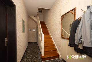 Bent u op zoek naar een ruime woning die u volledig naar eigen smaak en wensen kunt renoveren? Deze rijwoning aan de Emiel van Dorenlaan 16 in Genk biedt met een bewoonbare oppervlakte van maar liefst 168 m², drie slaapkamers, een uitbreidbare zolder én een polyvalente praktijkruimte bijzonder veel mogelijkheden. Een interessante opportuniteit voor wie op zoek is naar een renovatieproject op een uiterst gunstige locatie.<br /><br /><strong>Indeling</strong><br />Via de inkomhal betreedt u de woning met toegang tot de praktijkruimte en de leefruimte. De praktijkruimte op het gelijkvloers biedt verschillende mogelijkheden en leent zich uitstekend voor een zelfstandige activiteit, kantoor of thuiswerkplek en heeft een aparte voordeur. Wie liever extra woonruimte creëert, kan deze ruimte eveneens omvormen tot een gelijkvloerse slaapkamer of integreren in de bestaande leefruimte.<br /><br />De leefruimte geeft toegang tot de keuken. Via de aansluitende sas bereiken we het gastentoilet en de praktische garageberging. Zowel vanuit de leefruimte als via de sas heeft u toegang tot het terras en de achterliggende tuin.<br /><br />Op de eerste verdieping bevinden zich drie slaapkamers en een badkamer.<br /><br />Een bijkomende troef is de ruime zolderverdieping, bereikbaar via een vaste trap. Deze biedt nog heel wat potentieel en kan bij een renovatie verder ingericht worden tot één of meerdere extra slaapkamers, een bureau, hobbyruimte of andere invulling naar wens.<br /><br /><strong>Technische informatie</strong><br />De woning beschikt over een bewoonbare oppervlakte van ca. 168 m² en een perceel van 3a 7ca. De woning behaalt momenteel een EPC-label F en is bijgevolg onderhevig aan de renovatieverplichting en dient volledig gerenoveerd te worden, waardoor u de mogelijkheid krijgt om het pand technisch, energetisch én esthetisch volledig naar eigen smaak te vernieuwen. De ramen zijn deels voorzien van enkele en deels van dubbele beglazing in houten profielen. De verwarming gebeurt momenteel elektrisch. <br /><br /><strong>Buurtinformatie</strong><br />De woning geniet van een bijzonder gunstige ligging in Genk-Waterschei. De handelsstraten Hoevenzavellaan, Stalenstraat en Vennestraat bevinden zich vlakbij en bieden een uitgebreid aanbod aan winkels, supermarkten, horeca en andere dagelijkse voorzieningen. Ook de scholencampus van Genk en het SportinGenk Park zijn vlot te voet of met de fiets bereikbaar.<br /><br />Dankzij de nabijheid van de Westerring en de E314 geniet u bovendien van een uitstekende verbinding naar Genk-Centrum en de omliggende gemeenten. Een centrale locatie die bijzonder interessant is voor wie een ruime woning volledig naar eigen smaak wil transformeren, zonder in te boeten aan bereikbaarheid en dagelijkse voorzieningen.<br /><br />Bent u op zoek naar een renovatiepand met ruimte, potentieel en tal van mogelijkheden op een gunstige locatie in Genk? Contacteer ons via 089 69 30 01 of info@consimmo.be voor meer informatie of een bezoek ter plaatse. Bekijk ook de virtuele tour op onze website www.consimmo.be.