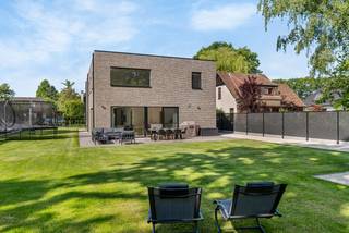 Deze eigendom is gelegen in een rustige omgeving op een perceel van ca. 1030 m². Het pand omvat oa. 4 slaapkamers, 2 badkamers, een bureauruimte, een lichtrijke leefruimte, etc. <br /><br />Indeling:<br />Gelijkvloers:<br />De ruime inkomhal op parket is voorzien van een ruime vestiairekast. Tijdens het ontwerp van de woning werd er ook gedacht aan de comfortabele routing. Zo kan men vanuit de inkomhal andere ruimtes bereiken; de leefruimte, het bureel en de afzonderlijke keukenberging.<br /><br />Bij het binnenkomen van de leefruimte, hebben we onmiddellijk een aangenaam open gevoel dankzij de keuken, leef-en zitgedeelte die in elkaar overvloeiien. Dit met een knipoog naar de tuin en het afsluitbaar bureel. <br />De keuken is volledig uitgerust en biedt meer dan voldoende werkruimte, mede dankzij het aanwezige eiland.<br />De bijkeuken is voorzien van vele kasten, een extra spoelbak en balansventilatie C.<br />Verder vinden we een handige wasplaats met maatkasten, op ergonomische hoogte geplaatste was-en droogvoorziening, CV-installatie, een comfortabele inloopdouche en een buitendeur naar de tuin.<br /><br />Eerste verdieping:<br />We nemen de trap naar de eerste verdieping. Ook hier werd bij het ontwerp nagedacht over lichtinval en het creëeren van een open gevoel. De overloop verbindt de vier slaapkamers, de twee badkamers en de masterbedroom met elkaar.<br />De master is opgedeeld in een slaapvertrek, een dressing en een comfortabele betegelde badkamer met dubbele wastafel met onderbouwkast, designbad, toilet en inloopdouche met regendouche..<br />De tweede badkamer is volledige betegeld, heeft een wastafel met opbergkast, een ruime inloopdouche en een toilet.<br /><br />Tuin:<br />De tuin is volledig omheind en ingericht met een ruim zonneterras.<br />Er werd een designschommel geplaatst en een bijgebouw dat naar believen kan afgewerkt worden voorzien als dubbele garage gezien de oprit tot daar doorloopt. Het bijgebouw is gemetst en reeds voorzien van isolatie in de muren.<br />Achter het bijgebouw is er een locatie om eventueel een aanhangwagen te stallen.<br /><br />Buitengewone kenmerken:<br />- EPC-label A <br />- Rustige ligging<br />- Groene omgeving<br />- Wachtbuizen voorzien om eventueel een zwembad te plaatsen<br />- Bijgebouw nog af te werken