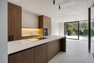 Deze stijlvolle nieuwbouwwoning is gelegen op een uitstekende locatie in het centrum van Geel, met de Markt op wandelafstand. Scholen, winkels, horeca en openbaar vervoer bevinden zich daardoor allemaal in de onmiddellijke omgeving. Ook de omliggende gemeenten zijn vlot bereikbaar.<br /><br />De woning onderscheidt zich door haar hoogwaardige afwerking, royale leefruimtes en overvloedige natuurlijke lichtinval. De doordachte architectuur, met onder meer een indrukwekkende vide en een centraal gelegen patio, zorgt op elke verdieping voor een bijzonder open en aangenaam ruimtegevoel.<br /><br />Beschrijving:<br />Op het gelijkvloers betreedt u de woning via een ruime inkomhal met vide, die meteen het open karakter van de woning benadrukt. Verder bevinden zich hier een gastentoilet, vestiaire, bureauruimte en een riante leef- en eetruimte met open keuken. De aansluitende patio brengt extra licht tot diep in de woning en vormt een mooie verbinding tussen de verschillende leefruimtes. Daarnaast is er een praktische berging aanwezig achter de keuken.<br /><br />De eerste verdieping omvat een ruime master bedroom met eigen dressing en badkamer met ligbad, wastafel en toilet. Daarnaast bevindt zich hier een bijkomende kamer die perfect dienst kan doen als logeerkamer, speelkamer of extra bureau.<br /><br />Op de tweede verdieping bevinden zich nog twee volwaardige slaapkamers, een hobbyruimte en een tweede badkamer met wastafel en inloopdouche.<br /><br />Buiten beschikt de woning over een gezellige privatieve stadstuin, waar u in alle rust kunt genieten van het zicht op de prachtig aangelegde binnentuin.<br /><br />Ook op energetisch vlak voldoet deze BEN-woning aan de hoogste hedendaagse standaarden. De woning werd gebouwd met doorgedreven isolatie en is onder meer uitgerust met zonnepanelen, een warmtepomp en ventilatiesysteem type D. Ook wat de afwerking betreft werd niets aan het toeval overgelaten: de woning wordt aangeboden met een bijzonder hoge afwerkingsgraad, tot en met de voorziene lichtarmaturen.<br /><br />Een bijkomende troef is de uitzonderlijk ruime kelder, die samen met twee ondergrondse autostaanplaatsen in de prijs is inbegrepen. Vanuit de ondergrondse parking heeft u bovendien rechtstreeks toegang tot de woning.<br /><br />Een unieke combinatie van luxueuze afwerking, licht, ruimte, energiezuinigheid en een centrale ligging in het hart van Geel.<br /><br />Meer informatie en/of een plaatsbezoek via info@vastengoed.be of 014/72.73.74.<br /><br />Wenst u een gratis schatting van uw eigendom? Contacteer ons vrijblijvend voor een afspraak!
