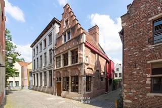 <p><span>Unieke eigendom in het Patershol<br /></span><span>Deze bijzondere eigendom bevindt zich in een van de meest toeristische en gegeerde plekjes van de stad.<br />Een romantisch straatje en een prachtige trapgevel springen meteen in het oog en verwelkomen je.<br /></span><span>Met een vloeroppervlakte van 161m², authentieke elementen en plafondhoogtes, is dit een uitzonderlijke woning op een exceptionele ligging in het hart van de stad.<br />De woning beschikt momenteel over een handelsruimte met bureel / kantoor, kelder, volledig ingerichte keuken, een royale leefruimte, 2 pelletkachels, 2 slaapkamers, toilet, berging en een badkamer.<br /></span><span><br /></span><span>Historisch erfgoed<br /></span><span>Dit h</span><span>oekhuis gaat terug tot de 16de eeuw en is opgetrokken in traditionele bak- en zandsteenbouw met een trapgevel en topstuk.<br />De zijgevel is voorzien van een gevelniskapel. <br />In 1980 werd een nieuwbouwinvulling gecreëerd door architect Monique Stoop in postmodernistische stijl. <br /><br /></span><span>Troeven</span><span><br />/ ligging<br />/ architectuur en historie<br />/ geen renovatieplicht (beschermd erfgoed)<br /><br />Een exceptionele eigendom door zijn stijl, ligging en historiek!</span></p><p><span>Mogelijkheid tot aankoop van een garagebox in de nabijgelegen Vrijdagmarkt.</span><span><br /><br /></span><span>Prijs op aanvraag<br /><br /></span></p>
