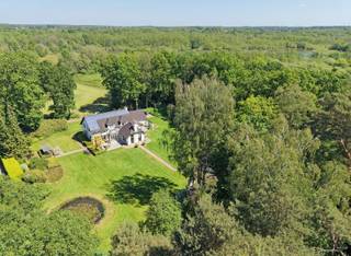 <p><span>Deze karaktervolle woning biedt een unieke combinatie van ruimte, rust en privacy in een groene en landelijke omgeving. Gelegen op een prachtig zuidgericht perceel van maar liefst 2ha 48a 40ca geniet u hier van een uitzonderlijk gevoel van vrijheid en een open zicht op de omliggende weilanden.<br /><br /></span></p><p><span>De woning werd gebouwd in 1980 en in 2003 uitgebreid met een bijkomende aanbouw. Doorheen de jaren werd ze steeds goed onderhouden en afgewerkt met kwalitatieve materialen, wat duidelijk voelbaar is in de aangename en verzorgde sfeer die het huis uitstraalt. Bovendien is de volledige eigendom vergund.</span></p><p><span> </span></p><p><span>Bij het betreden van de woning komt u binnen in de inkomhal met gastentoilet, waarna u wordt verwelkomd in de ruime en gezellige leefruimte. Deze bestaat uit een woonkamer, TV-hoek, eetplaats en bureelhoek, waardoor er een aangename indeling ontstaat die zowel praktisch als huiselijk aanvoelt. Aansluitend bevindt zich de lichtrijke tuinkamer met prachtig zicht op de tuin en het omliggende groen. De keuken, bijkeuken/wasplaats en toegang tot de kelder maken het gelijkvloers compleet en functioneel.<br /><br /></span></p><p><span>Op de verdieping geeft de nachthal toegang tot vier volwaardige slaapkamers, een badkamer en een zolderberging. De woning beschikt daarnaast over een dubbele inpandige garage met extra zolderruimte.</span></p><p><span> </span></p><p><span>Ook de buitenomgeving is een absolute troef. De aangelegde tuin met vijver, het overdekte terras en het tuinhuis creëren een aangename plek om te genieten van de rust. De omliggende weilanden versterken het gevoel van ruimte en bieden tal van mogelijkheden voor dierenliefhebbers of wie gewoon wil genieten van volledige privacy.<br /><br /></span></p><p><span>Extra comfort wordt geboden door onder andere zonnepanelen, verwarming op stookolie, houtkachels, parketvloeren, houten ramen, sierradiatoren en een alarmsysteem. Alles samen maakt dit een woning die zowel karaktervol als praktisch is, en bovendien zeer goed onderhouden werd.</span></p><p><span> </span></p><p><span>De ligging, de uitzonderlijke perceelgrootte, de zuidoriëntatie en de totale privacy maken van deze eigendom een zeldzame kans voor wie op zoek is naar landelijk wonen op hoog niveau.</span></p>
