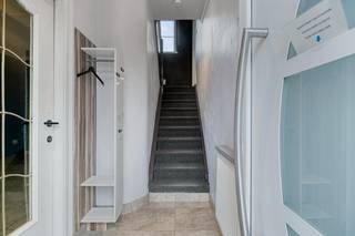 We betreden de woning via de inkomhal, die toegang biedt tot de gezellige leefruimte met inbouwhaard.Achteraan bevindt zich de vernieuwde keuken,...