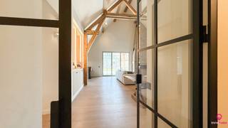 Bij ImmoFusion 7/7 “open huis” : klik op onze 3D-TOUR.<br />Ervaar vastgoed alsof je er zelf doorloopt!<br /><br />Welkom in deze prachtige gelijkvloerse nieuwbouwwoning in pastorijstijl, waar high-end afwerking, licht en ruimte centraal staan. Deze woning is bovendien ideaal voor een koppel dat in alle comfort volledig gelijkvloers wil wonen, zonder in te boeten aan praktische opbergruimte dankzij de ruime ondergrondse kelder.<br /><br />Van bij het betreden van de woning ervaar je meteen het gevoel van openheid en luxe. In de inkomhal bevinden zich het gastentoilet en de eerste ruime slaapkamer, die bovendien beschikt over een handig luik naar de zolder.<br /><br />De leefruimte vormt het absolute hart van de woning en imponeert door de uitzonderlijk hoge plafonds, die zorgen voor een ongeëvenaard ruimtelijk gevoel. Het warme karakter van houtaccenten en kwalitatief parket creëert een gezellige en stijlvolle sfeer. De houtstoof is hierbij een echte troef en maakt de winteravonden extra aangenaam.<br /><br />Aansluitend bevindt zich de moderne keuken met een groot en praktisch eiland, volledig uitgerust met een microgolf, oven, inductiekookplaat, dampkap en afwasmachine. Achter de keuken ligt een functionele berging die dienstdoet als wasruimte en voorzien is van alle nodige aansluitingen.<br /><br />Links van de leefruimte bevindt zich de tweede slaapkamer, met daarachter de comfortabele badkamer. Deze is uitgerust met een toilet, een ruim badkamermeubel met dubbele wastafel, een inloopdouche en praktische inbouwkasten.<br /><br />Het volledige pand is onderkelderd en beschikt over een grote, droge kelder die bovendien bereikbaar is via een lift, wat het wooncomfort aanzienlijk verhoogt en zorgt voor uitzonderlijk veel extra bergruimte. Buiten geniet je van een overdekt terras en een zeer ruime carport voor twee wagens, uitgerust met een laadpaal.<br /><br />Dankzij het uitstekende E3-peil geniet je bovendien van een vrijstelling van onroerende voorheffing gedurende vijf jaar. De woning is voorzien van zonnepanelen, een warmtepomp en vloerverwarming, wat zorgt voor een uiterst energiezuinig en toekomstgericht wooncomfort.<br /><br />Pluspunten:<br />- Gelijkvloerse high-end nieuwbouwwoning in pastorijstijl<br />- Ideaal voor comfortabel gelijkvloers wonen met veel opbergruimte<br />- Zeer lichtrijk met uitzonderlijk hoge plafonds in de leefruimte<br />- Volledig onderkelderd met lift<br />- Energiezuinig: E3-peil, zonnepanelen en warmtepomp<br />- Vloerverwarming in de volledige woning<br />- Overdekt terras en carport voor 2 wagens met laadpaal<br />- Warme en luxueuze afwerking met hout en parket<br /><br /><span>Maatregelen opgenomen in het Maatregelenregister: nee</span><br /><br />Voor een bezichtiging ter plaatse of meer info, bel ons op 078/78.78.70, of kom gewoon binnen op ons kantoor, steeds welkom!