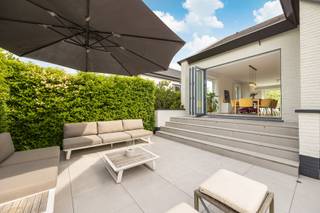 <p>Rustig gelegen vlakbij het kasteel van 's Gravenwezel bevindt zich deze split-level woning op ca. 1103 m² in een doodlopende straat.</p>
<p><br /><span><strong>Indeling</strong></span></p>
<p>Inkomhal met gastentoilet en vestiairekast.</p>
<p>Verdieping + 0,5 : Toegang tot de royale leefruimte op parket, ingedeeld in een ruim salon voorzien van een gashaard en een eetkamer. Dankzij de vele en grote raampartijen is er een overvloed aan natuurlijke lichtinval.</p>
<p>De leefruimte bevindt zich tussen twee terrassen: aan de voorzijde geeft een schuifraam toegang tot het voorterras, terwijl de achterzijde is voorzien van een volledig glazen vouwwand naar het achterterras. Als beide worden geopend, vloeien binnen- en buitenruimte naadloos in elkaar over, waardoor de leefruimte een open en ruimtelijk gevoel creëert. De natuurlijke ventilatie zorgt bovendien voor een aangename, frisse bries doorheen de woning.</p>
<p>Vanuit de leefruimte is er toegang tot de vernieuwde maatkeuken (2020), voorzien van alle hedendaagse comfort en is uitgerust met een werkblad in composiet, een combioven/stoomoven, een combioven/microgolfoven, kookplaat, dampkap, vaatwasmachine, koelkast, diepvriezer en tal van praktische opbergladen.</p>
<p>Zowel vanuit de leefruimte als vanuit de keuken is er toegang tot het ruime terras van ca. 60 m²(2020) en de omheinde tuin.</p>
<p>Op deze verdieping bevindt zich eveneens de hoofdslaapkamer met ingemaakte kasten en een ensuite badkamer uitgerust met een dubbele lavabo en ligbad met douche combinatie.</p>
<p><strong><span>Verdieping +1</span>:</strong> overloop met een aparte bureau- of hobbyruimte.</p>
<p><strong><span>Verdieping +1,5</span>:</strong> twee slaapkamers tot in de nok van het dak, waarvan één ruime kamer, een badkamer uitgerust met een dubbele lavabo en ligbad, en een apart toilet op de nachthal. Op deze verdieping bevindt zich tevens een zolderberging, die mogelijkheden biedt voor extra bergruimte of een uitbreiding van de slaapkamer.<br /><br /><span><strong>Bijzonderheden</strong></span><br />- luchtverwarming op aardgas<br />- overal nieuwe ramen - PVC of aluminium (2020)<br />- bevloering parket en marmer<br />- zonneluifel aan het terras vooraan<br />- zonnewering slpkrs. boven<br />- dubbele inpandige garage met sectionaal poort<br />- ruime kelder en kruipkelder <br />- recente schilderwerken<br />- elektriciteit conform<br />- EPC label D - 395 kWh/m²<br /><br /><span><strong>Stedenbouw</strong></span>: Vg-Wp-Gvv-Gvkr-Gmo-Gworg</p>