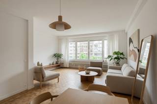 Ruim appartement op centrale locatie met terras én balkon<br /><br />Op een boogscheut van het Stadspark, op de 4e verdieping, ligt dit ruime en lichtrijke appartement. Het is bereikbaar via lift of trap.<br />Bij binnenkomst valt meteen de ruime inkomhal op, voorzien van ingemaakte kasten en een aansluiting voor de wasmachine.<br />Aan de voorzijde bevindt zich de royale leef- en eetruimte met authentieke houten blokjesparketvloer. Dankzij de grote raampartijen is er een prachtige lichtinval. Het uitzicht over de straat met veel groen aan de overkant zorgt voor een open en ruimtelijk gevoel.<br />Aansluitend bevindt zich de recent volledig gerenoveerde keuken, uitgerust met een inductiekookplaat met ingebouwde dampkap, combi-oven, heteluchtoven en vaatwasser. Een groot pluspunt is het aangrenzende balkon.<br />Achteraan de woning liggen twee slaapkamers, een apart toilet en de badkamer. Zowel de badkamer (met inloopdouche en lavabomeubel) als het toilet werden recent vernieuwd.<br />De grote slaapkamer biedt directe toegang tot het ruime, zonnige terras aan de achterzijde.