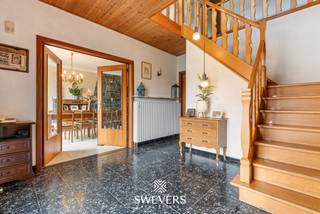 Voor meer info en foto’s, surf naar www.swevers.be – Aan de Schootstraat 128 in Heusden-Zolder vind je deze ruime open bebouwing op een zuidelijk georiënteerd perceel van 10a 85ca. De woning uit 1964 biedt 199 m² bewoonbare oppervlakte en vormt dankzij haar ruime indeling en renovatiemogelijkheden een interessante basis voor wie een gezinswoning volledig naar eigen smaak wil creëren. Op het gelijkvloers bevinden zich een centrale inkomhal, een living van 32 m², eetplaats, keuken van 16 m², badkamer, apart toilet en een extra woonkamer. Deze tweede leefruimte kan flexibel worden ingericht als bureau, hobbyruimte, slaapkamer of bijkomende zithoek. De woning telt vier slaapkamers van 34 m², 19 m², 18 m² en 11 m². Daarnaast is de woning grotendeels onderkelderd met onder meer een inpandige garage. Ook rolluiken zijn aanwezig. Het royale perceel met zuidelijke oriëntatie biedt volop mogelijkheden voor een aangename tuin en terras. De ligging combineert rust en groen met een goede bereikbaarheid. De Vallei van de Mangelbeek ligt op slechts 200 meter, openbaar vervoer op 50 meter en scholen en winkels op circa 550 meter. Ook de E313 en E314, Hasselt en Beringen zijn vlot bereikbaar. Een woning met veel ruimte, licht en potentieel voor wie grondig wil renoveren en een thuis op maat wil realiseren. Voor meer informatie, bel 011 255 155. Bron bewoonbare oppervlakte: EPC – verslag. Dit pand is onderworpen aan de renovatieverplichting van de Vlaamse overheid voor residentiële gebouwen (behoudens bij sloop binnen 5 jaar na de aankoop). Consulteer voor meer informatie de website van het Vlaams Energie- en Klimaatagentschap via https://www.vlaanderen.be/een-huis-of-appartement-kopen/renovatieverplichting-voor-residentiele-gebouwen.