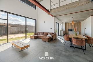 Voor meer info en foto’s, surf naar www.swevers.be – In een rustige, groene buurt van Herk-de-Stad vind je deze instapklare open bebouwing aan de Terbermenweg 156. De woning werd volledig gebouwd tot een moderne, energiezuinige thuis met zonnepanelen en mogelijkheid tot airco. Met een bewoonbare oppervlakte van 184 m² biedt het pand veel ruimte en comfort. De lichtrijke leefruimte (37 m²) sluit naadloos aan op de ruime keuken (28 m²) met kookeiland en directe toegang tot de zuidgerichte tuin. Verder op het gelijkvloers: een praktische berging, een gastentoilet en een aparte slaapkamer of bureauruimte. Boven bevindt zich een ruime slaapkamer, een moderne badkamer met inloopdouche en dubbele wastafel, een extra toilet en een open nachthal met vide. Er is een mogelijkheid om hier nog een extra slaapkamer te realiseren van 15,75 m², indien nodig en na bespreking met de eigenaar. De woning beschikt niet over een kelder of zolder, maar biedt voldoende bergruimte (17,8m² ). Gelegen op 6 are en op korte afstand van winkels, scholen, openbaar vervoer en snelwegen, combineert deze woning rust met bereikbaarheid. Voor meer informatie, bel 011 255 155. Bron bewoonbare oppervlakte: EPC – verslag.
