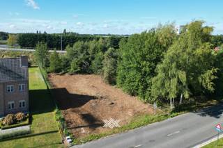 Deze zuidwest georiënteerde bouwgrond met een oppervlakte van 872 m² is gelegen te Drongen. Het perceel is gelegen in een verkaveling waardoor, rekening houdend met de officiële bestemming in agrarisch gebied, de opbouw van een woning mogelijk is zonder bestemmingswijziging. Dit perceel is zeer vlot bereikbaar dankzij de goede ontsluiting met de E40. De bouwgrond is geschikt voor het bouwen van een open bebouwing (landelijk karakter) met een maximale diepte van 20 m op het gelijkvloers en 15 m op de verdieping. Op deze grond kan een woning geconstrueerd worden, afgewerkt met een zadeldak en een kroonlijst van maximaal 6 m. Een eventuele afzonderlijke garage kan opgericht worden op minstens 20 m achter de voorbouwlijn, met een maximale oppervlakte van 32 m². Verder is er een zijdelings bouwverbod van 4 m beginnend vanaf de perceelsgrens van aanpalende percelen. In de tuinzone achter de woning kan een constructie (berging, serre…) worden opgericht op minstens 30 m van de voorbouwlijn met een maximale hoogte van 3,5 m. Verder zal het bijgebouw dienen afgewerkt te worden met dezelfde materialen als het hoofdgebouw. Dit perceel biedt dus een mooie kans voor het bouwen van een open gezinswoning in een groene en vlot bereikbare omgeving. Er is tevens geen bouwverplichting wat betekent dat u vrij bent te kiezen wanneer u uw droomwoning bouwt.
