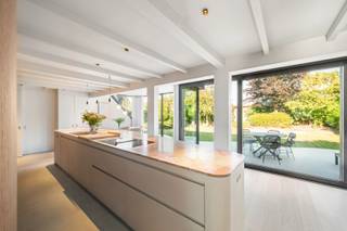 In een rustige, doodlopende straat , op slechts enkele minuten van het centrum van Knokke, bevindt zich deze uitzonderlijk gerenoveerde vrijstaande woning. Als voorlaatste woning in de straat geniet U hier van maximale privacy, een oase van rust en tegelijk een uitstekende bereikbaarheid van winkels, scholen, horeca en alle dagelijkse voorzieningen.<br /><br />Deze woning werd volledig op maat ontworpen voor comfortabel wonen, waarbij elk detail zorgvuldig werd uitgewerkt. Geen standaard renovatie, maar een doordacht totaalconcept waarin hoogwaardige materialen, verfijnde afwerking en praktisch wooncomfort harmonieus samenkomen. Doorheen de volledige woning werden maatwerkkasten geïntegreerd, subtiele indirecte verlichting accentueert de architectuur en zelfs de kleinste details, zoals discreet weggewerkte stopcontacten, dragen bij aan de luxueuze uitstraling. Op maat gemaakte gordijnen en de clay-stucafwerking over de volledige woning vervolledigen het geheel.<br /><br />Bij het betreden van de woning wordt U verwelkomd in een royale inkomhal met een indrukwekkende plafondhoogte. Een stijlvolle vestiairekast op maat, indirecte wandverlichting, een elegante gietvloer en een gastentoilet zetten onmiddellijk de toon.<br /><br />De leefruimte baadt dankzij de plafondhoge raampartijen in natuurlijk licht. Binnen en buiten vloeien naadloos in elkaar over, waardoor een bijzonder aangenaam ruimtegevoel ontstaat. De warme parketvloer en de op maat gemaakte kastenwand, die harmonieus doorloopt van de woonkamer naar de keuken, zorgen voor een strak en tijdloos interieur.<br /><br />De keuken vormt zonder twijfel het kloppende hart van de woning. Het organisch gevormde kookeiland met luxueus marmeren werkblad nodigt uit om samen te koken, aperitieven of gezellig aan de bar te ontbijten. De lichte clay-stucafwerking vormt een stijlvol contrast met de donkere maatwerkkasten en creëert een hedendaagse, verfijnde sfeer. Aansluitend bevindt zich de lichtrijke eetplaats met een prachtig zicht op de tuin.<br /><br />Praktisch comfort ontbreekt evenmin. Naast de keuken bevindt zich een volledig ingerichte wasruimte met maatwerkkasten, aansluitingen voor wasmachine en droogkast en een afzonderlijke zij-ingang. De inpandige garage biedt plaats aan een wagen en beschikt bovendien over extra ruimte voor fietsen, bromfietsen of bijkomende stockage. Ook op de oprit is er parkeergelegenheid voorzien voor twee wagens.<br /><br />De onderhoudsvriendelijke tuin werd aangelegd met oog voor rust en esthetiek. Het organisch gevormde natuurstenen terras vormt een verlengstuk van de leefruimte en biedt de ideale setting om in alle privacy van het buitenleven te genieten.<br /><br />Op de eerste verdieping bevindt zich de stijlvolle masterbedroom met maatwerkkasten en de ensuite badkamer beschikt over een ligbad, inloopdouche, wastafel en toilet. <br /><br />Daarnaast zijn er nog twee volwaardige slaapkamers die beiden toegang hebben tot een badkamer met inloopdouche, wastafel alsook een afzonderlijk toilet. <br /><br />Deze instapklare woning combineert hedendaagse architectuur, hoogwaardige materialen en een bijzonder doordachte indeling tot een unieke woonervaring. Een eigendom waar design, comfort en functionaliteit elkaar perfect versterken.<br /><br />Bent U op zoek naar een exclusieve woning waar rust, luxe en wooncomfort centraal staan, op een toplocatie nabij het centrum van Knokke? Contacteer ons vandaag nog voor meer informatie of plan een bezoek en laat u ter plaatse overtuigen door de uitzonderlijke afwerking en het unieke karakter van deze prachtige eigendom.