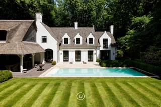 Située dans le prestigieux et verdoyant Sint-Martens-Latem, cette magnifique villa entièrement prête à l'emploi se trouve sur un magnifique terrain de 2 178 m². La propriété combine des espaces de vie généreux, une finition de haute qualité et un confort contemporain avec un emplacement exceptionnel et un jardin entièrement aménagé avec piscine.<br /><br />La villa comprend notamment:<br />Rez-de-chaussée<br />• Grand hall d'entrée avec vestiaire et toilettes invités<br />• Cuisine entièrement équipée avec des appareils Gaggenau de haute qualité, une chambre froide et une buanderie / bar à café attenante<br />• Salle à manger adjacente de taille normale avec une vue magnifique sur le jardin et un accès direct à la terrasse couverte<br />• Bureau spacieux, idéal pour le travail à domicile ou comme espace de travail séparé<br />• Salon chaleureux et spacieux avec cheminée, donnant sur le jardin magnifiquement aménagé<br /><br />Premier étage<br />• Grande chambre principale avec dressing sur mesure<br />• Salle de bains luxueuse avec sauna<br />• Trois chambres supplémentaires, chacune avec sa propre salle de bains attenante<br />• Buanderie spacieuse et pratique<br /><br />Expérience en plein air:<br />Le jardin entièrement aménagé avec terrasse couverte est un havre de paix et d'intimité. La piscine avec salle de bain attenante offre une expérience de vie et de détente exceptionnelle.<br /><br />Cave & espace de rangement<br />La maison dispose également d'une cave spacieuse avec cave à vin et espace de rangement supplémentaire.<br /><br />Garage & parking<br />Le garage intégré peut accueillir deux voitures et, si nécessaire, peut également être aménagé en espace de bureau ou polyvalent grâce au chauffage disponible. De plus, la villa dispose d'une grande allée avec un parking pour plusieurs voitures.<br /><br />Une maison exceptionnelle pour ceux qui recherchent de l'espace, du confort, de l'intimité et une finition de haute qualité dans un emplacement recherché.